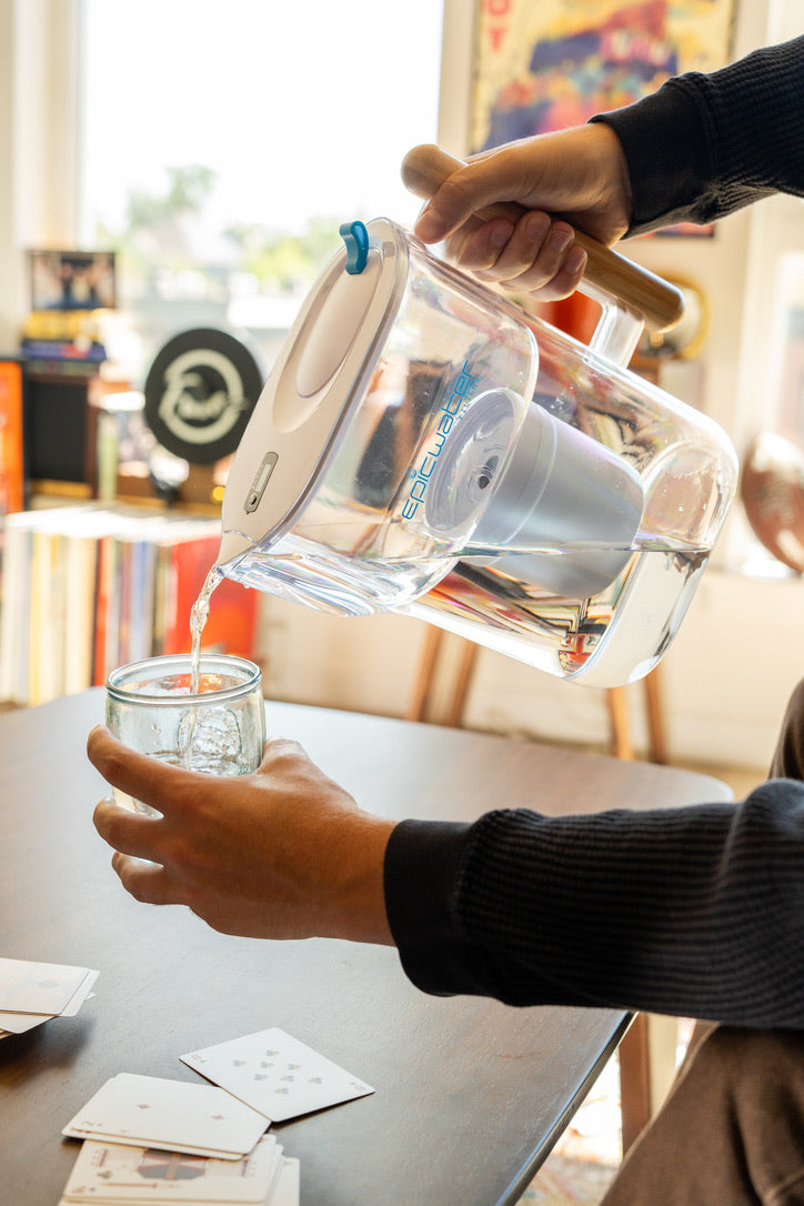 Epic Water Filters Pure XP pitcher with red handle and clear body, designed to reduce fluoride, PFAS, and parasites from drinking water.
