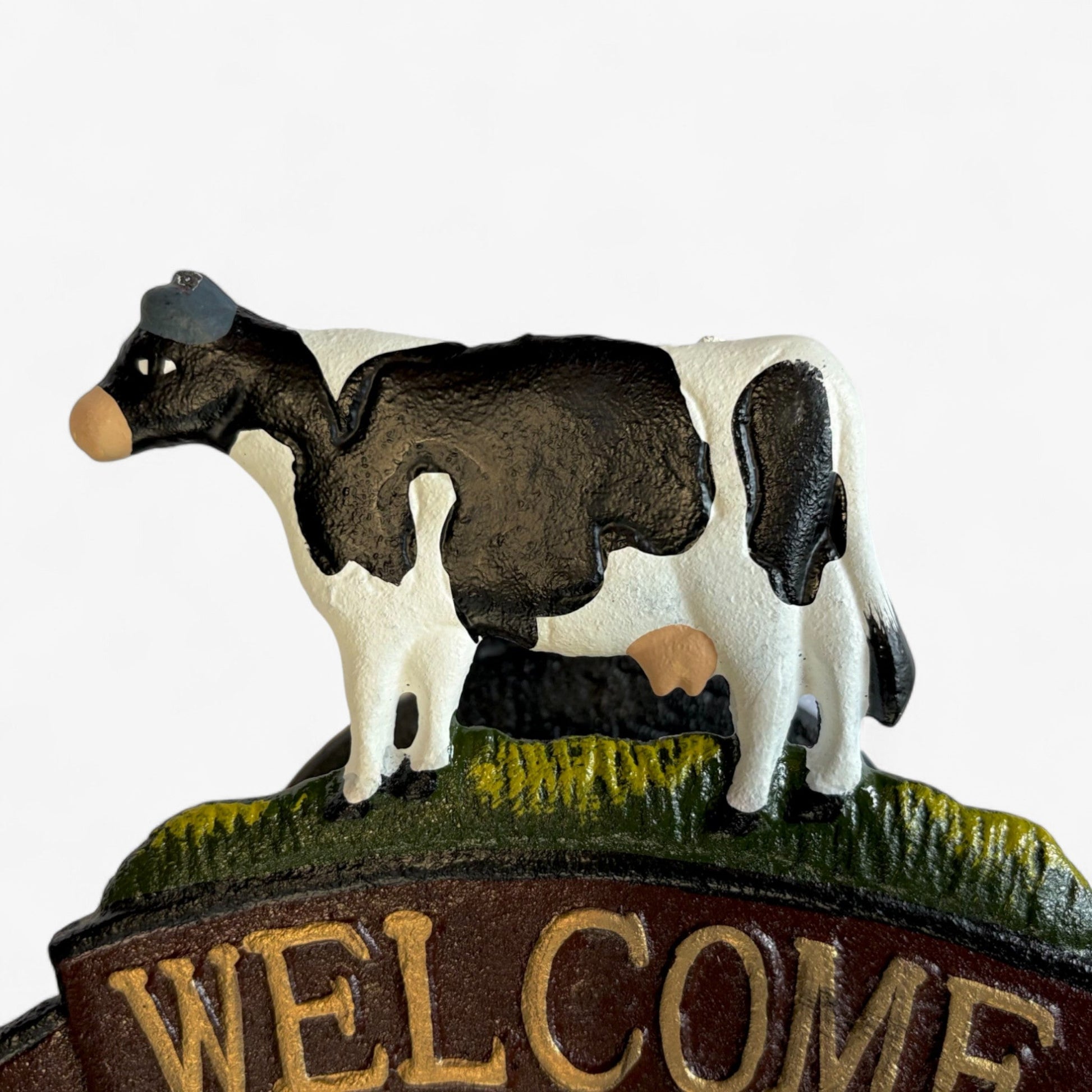 Rustic cast iron cow welcome bell sign with farmhouse decor style, featuring Iron & Blossom branding for rustic door accents.