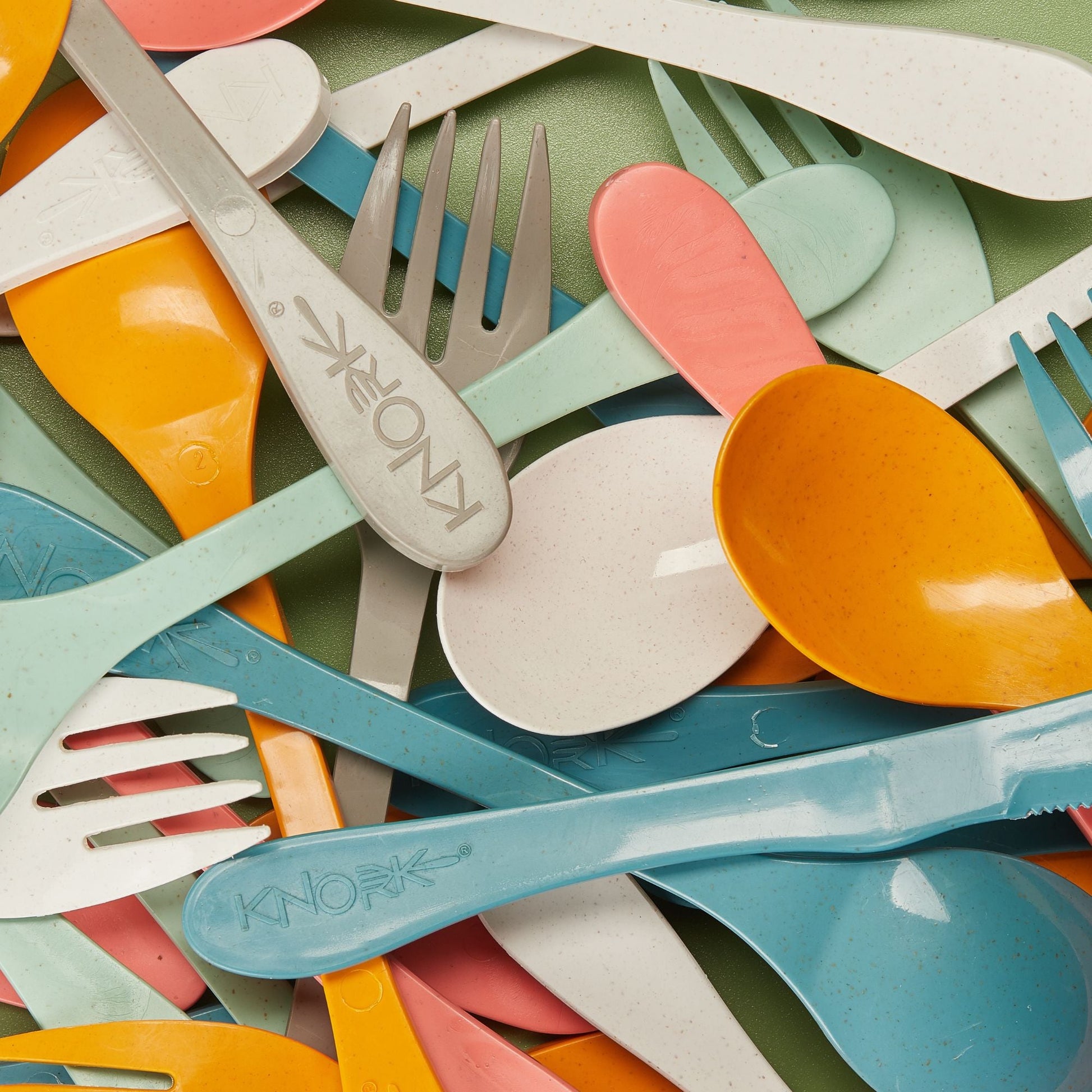Set of 12 Eco Knork utensils including forks, knives, and spoons made from eco-friendly materials arranged on a white background.