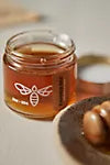 Assorted honey flight by BannerBee Company LLC featuring small jars of honey varieties displayed on a wooden tray.
