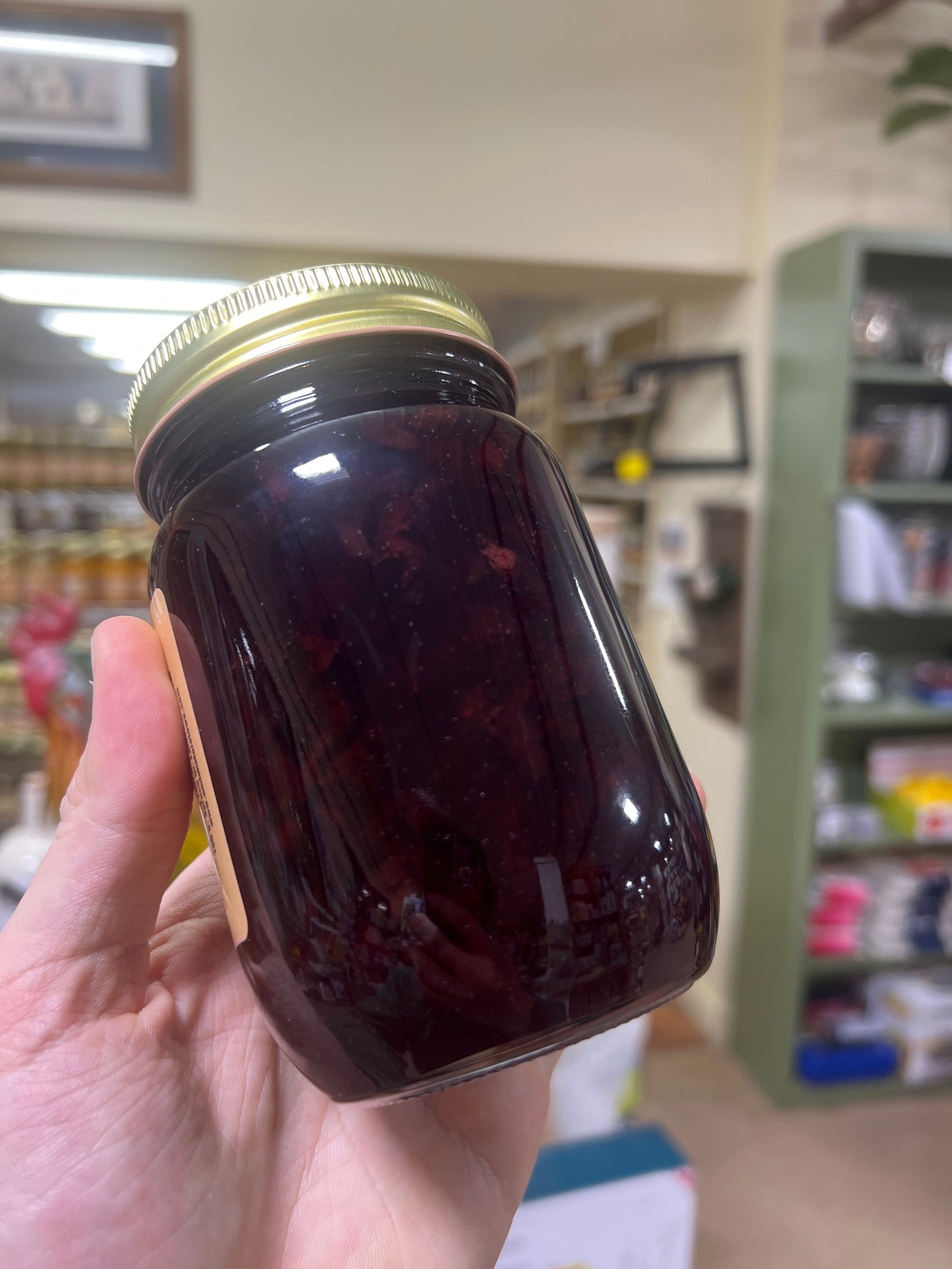 Canned Black Cherry Jam from Amish Country Store in an 18 oz jar, with black cherries and jam visible inside.