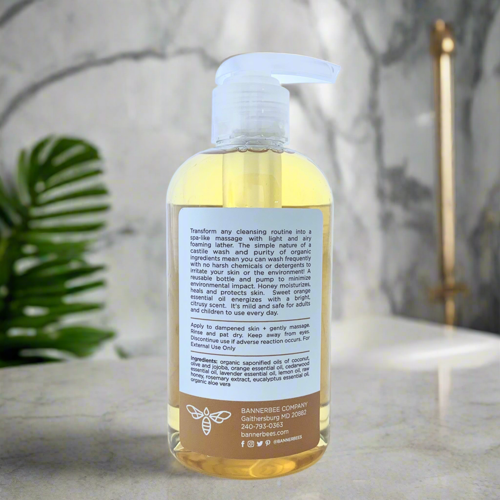 Organic Castile Hand and Body Wash by BannerBee Company LLC with citrus blossom scent, showcasing the bottle and fresh ingredients.