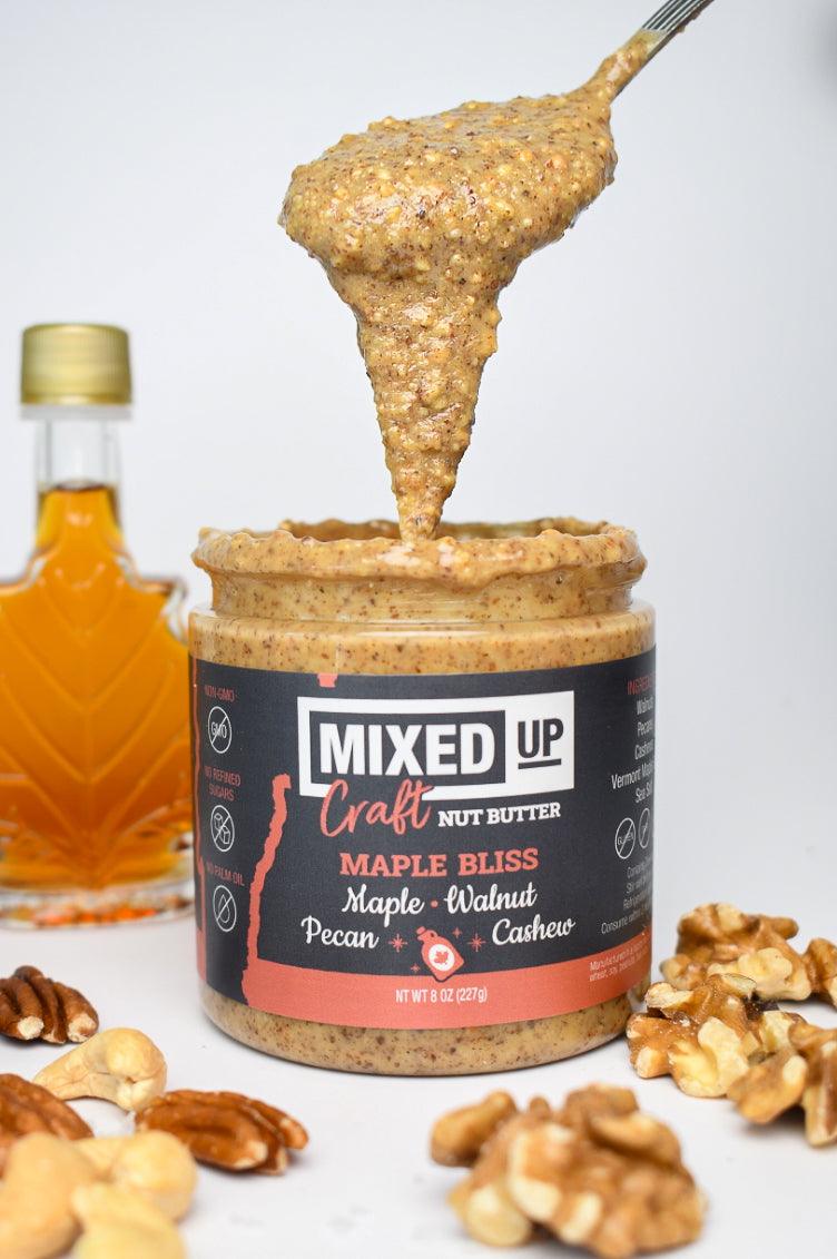 Creamy Maple Bliss nut butter by Mixed Up Foods with walnut, pecan, and maple in an 8 oz jar, showing a smooth, textured spread.
