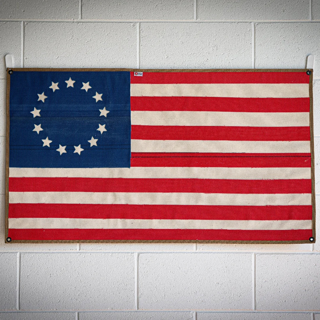 American flag made from recycled fire hose with Betsy Ross design by Recycled Firefighter, displayed on a white background.