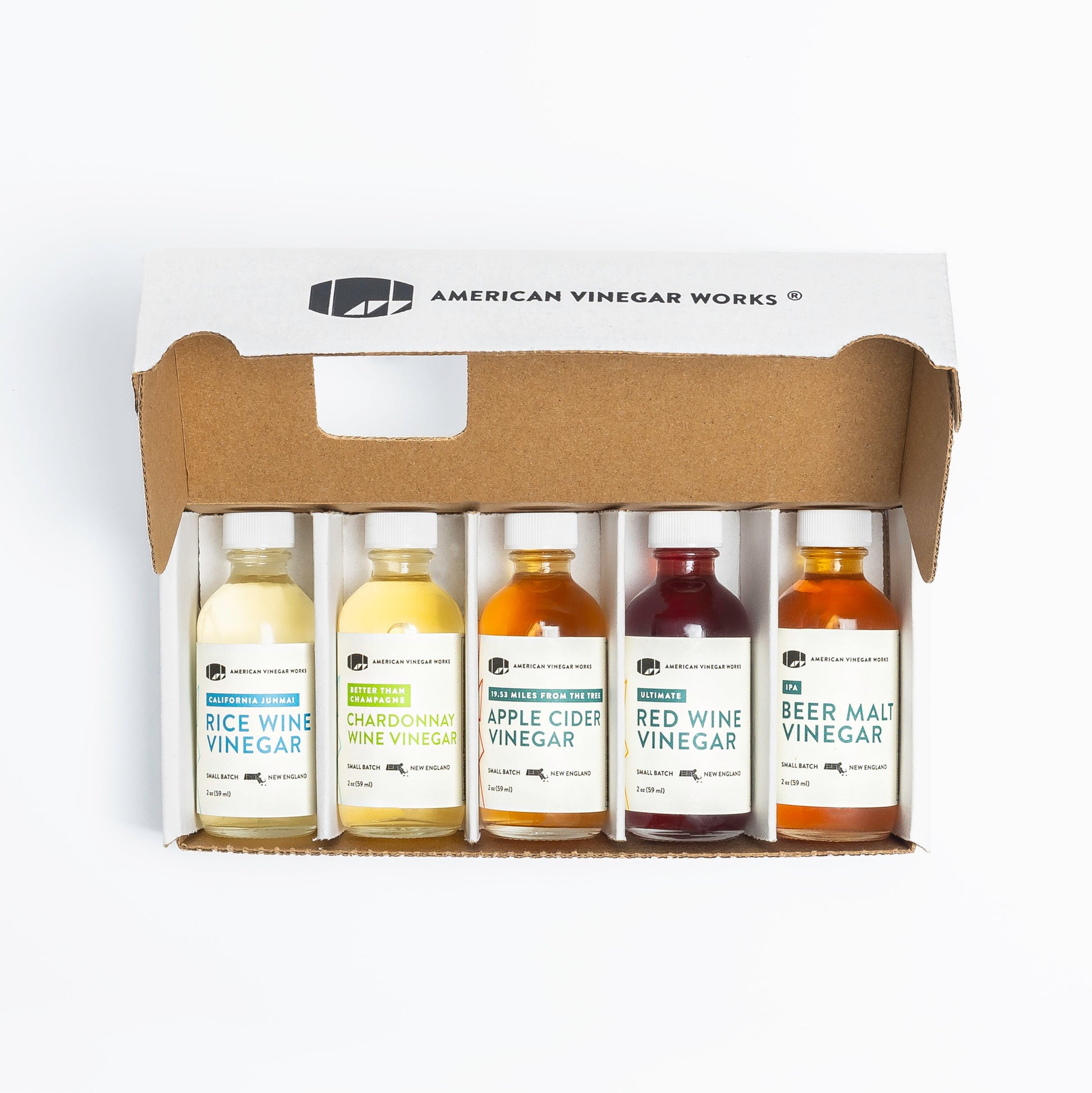 American Vinegar Works Essentials Plus vinegar sampler set featuring five barrel-aged vinegar bottles in a natural wooden display