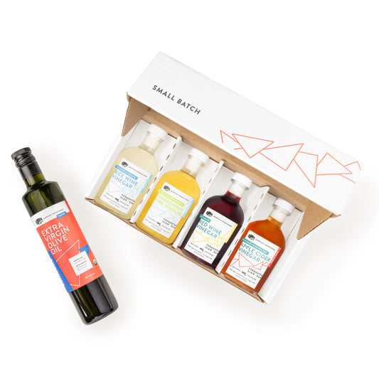Small batch American Vinegar Works gift set featuring assorted kitchen and cooking vinegars in glass bottles.