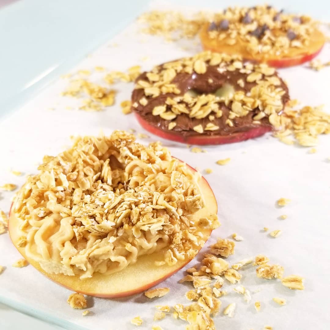 Pack of two 12 oz peanut butter granola food multipacks from The Gourmet Granola, gluten, soy, and dairy free, with apple donuts in the image.