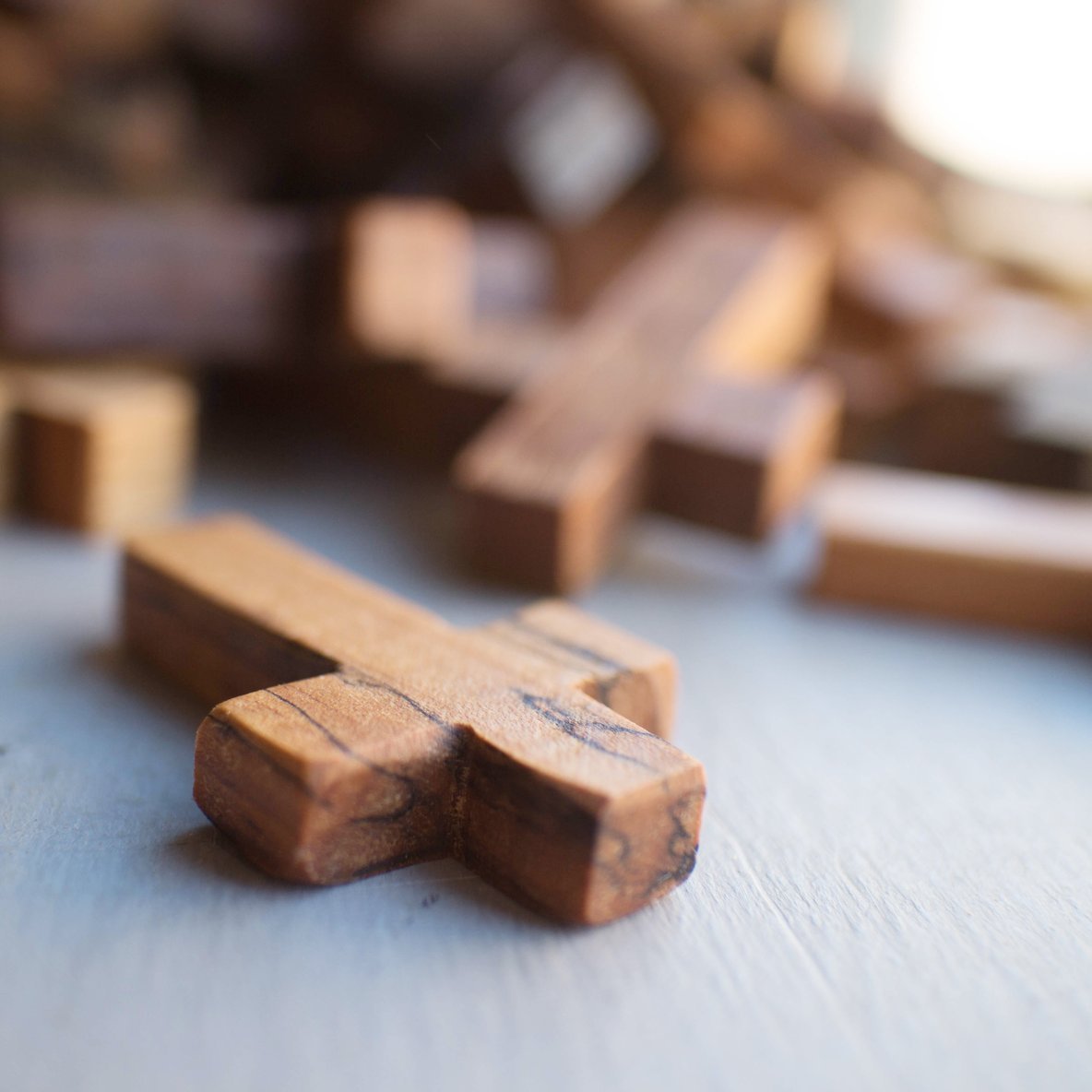 Handmade wooden pocket crosses by Dennehey Design Co. featuring small, carved wooden crosses suitable for personal keepsakes.