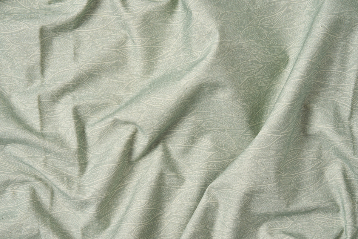 Cotton bed sheet set with green leaf print from American Blossom Linens, close-up of fabric showing detailed leaf pattern on green background