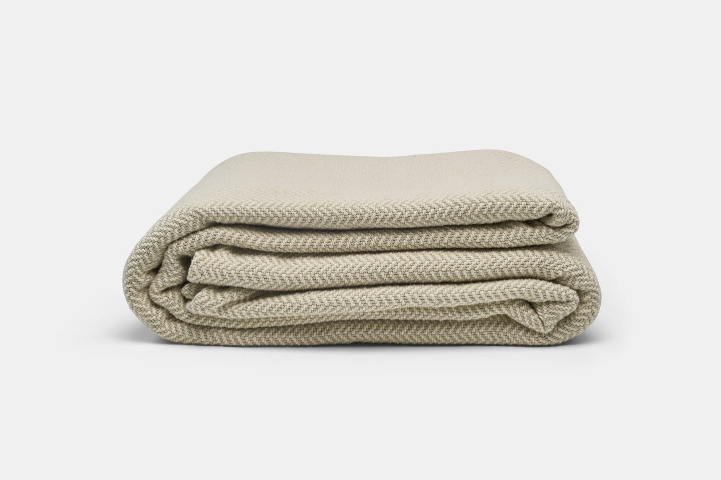 Green herringbone weave cotton blanket from American Blossom Linens, showing soft textured fabric and cozy design.