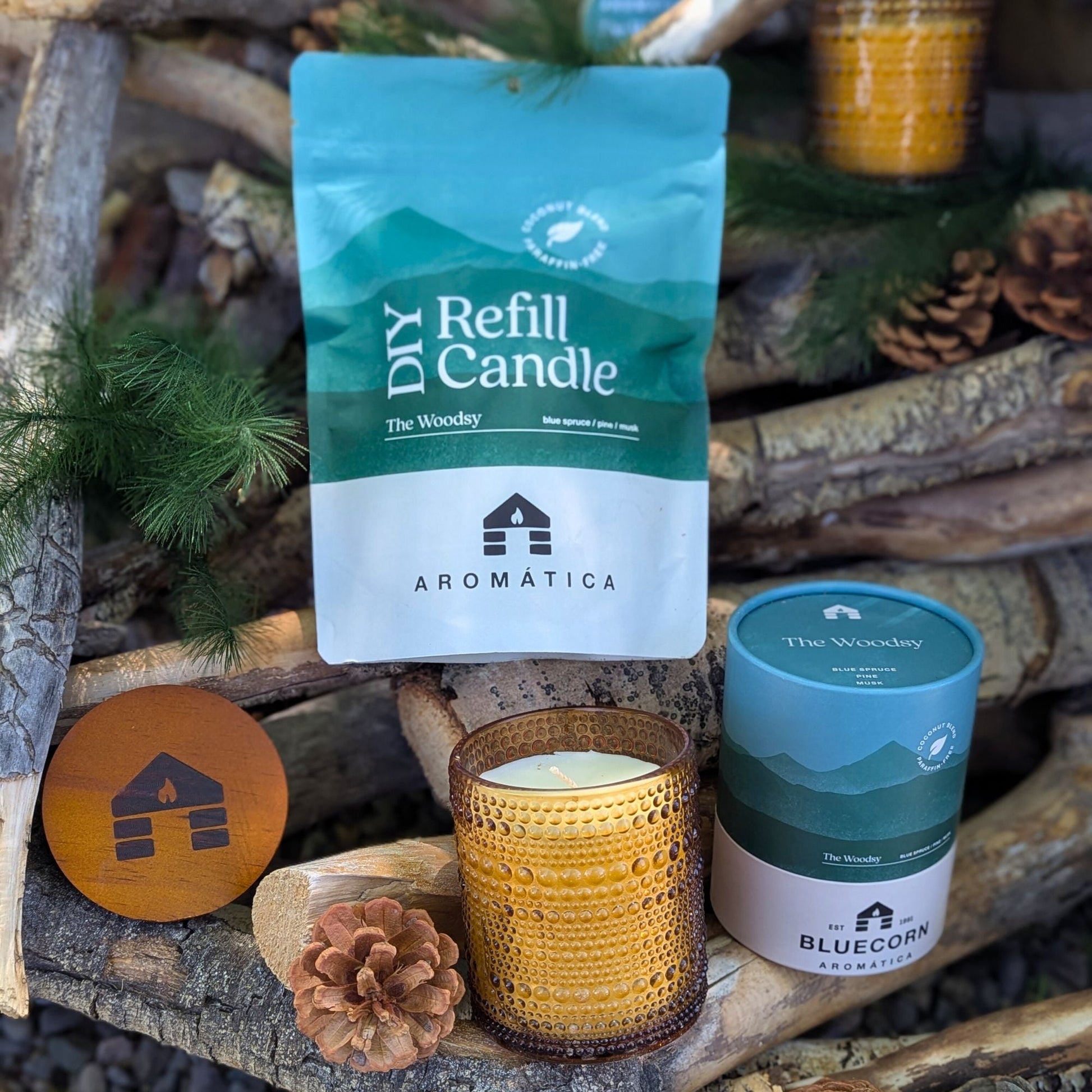 Bluecorn Candles Aromática scented candle refill kit with coconut wax, featuring a woodland pine aroma in a natural setting.