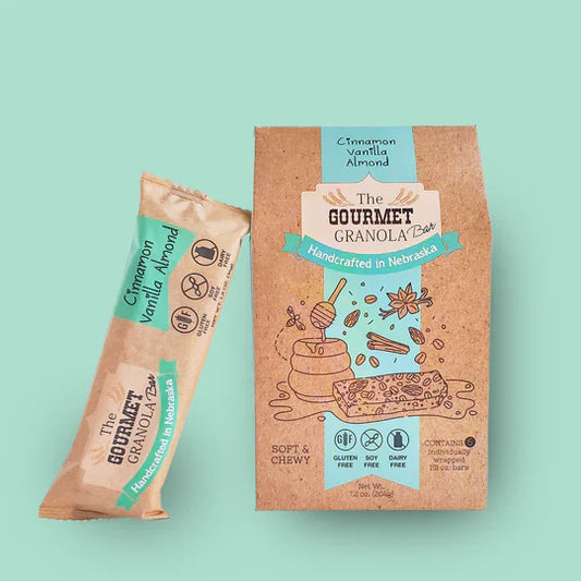 Cinnamon vanilla almond granola bars from The Gourmet Granola in a pack of six, gluten, dairy, and soy free, on a teal background.