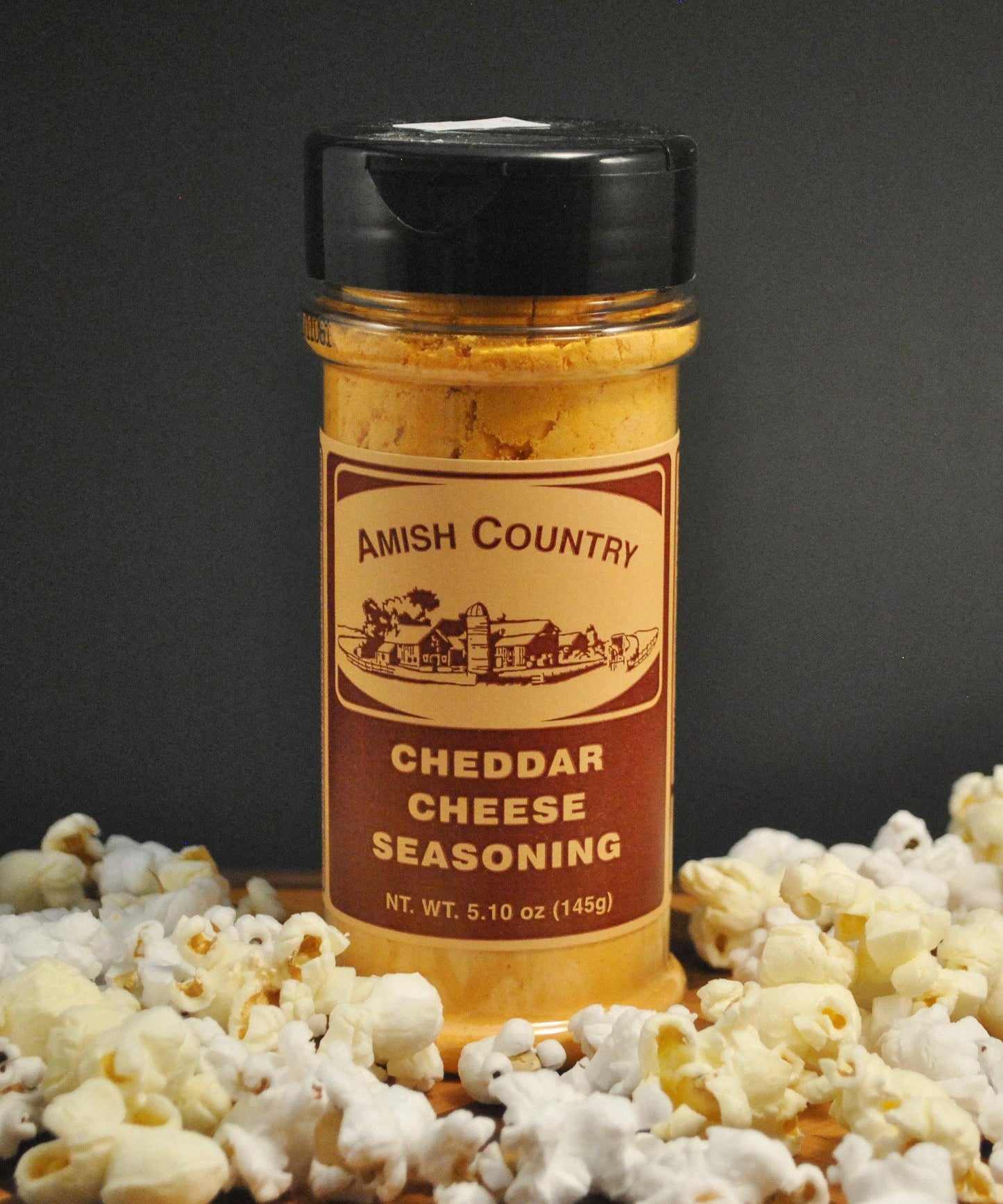 Amish Country Store cheddar cheese popcorn seasoning in a jar, perfect for flavoring Amish Popcorn snacks.