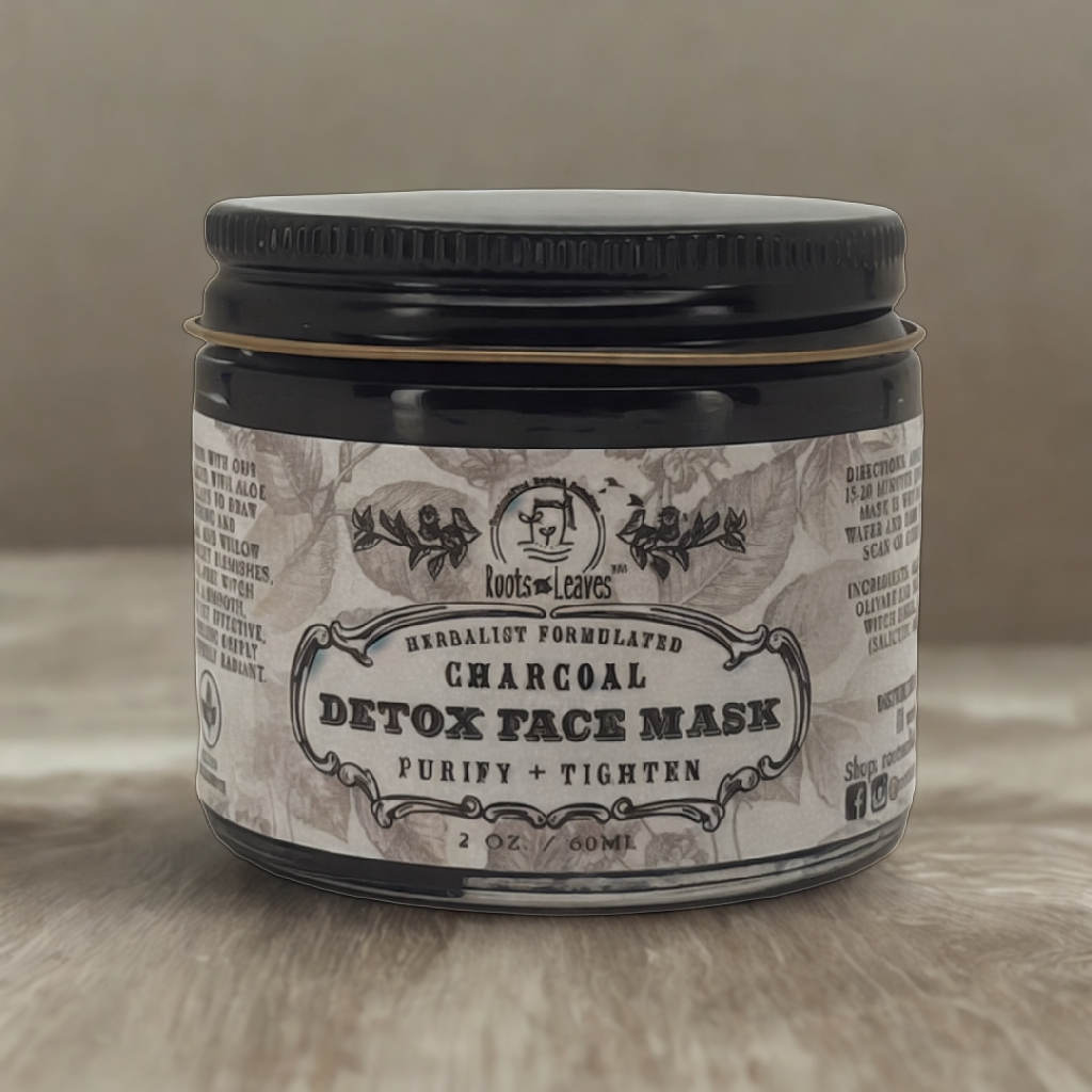Creamy charcoal detox face mask from Roots and Leaves LLC spread evenly on a skincare bowl, ready for application.
