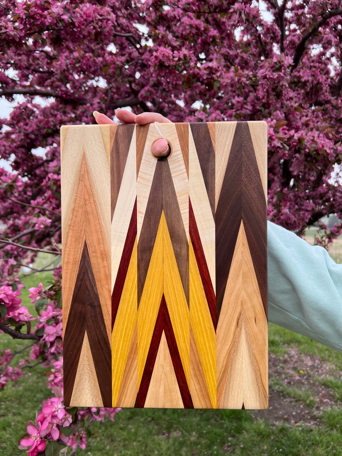 Handcrafted Amish chevron cutting board with multi-wood inlay and beeswax finish, 9.5x14 inches for kitchen use.