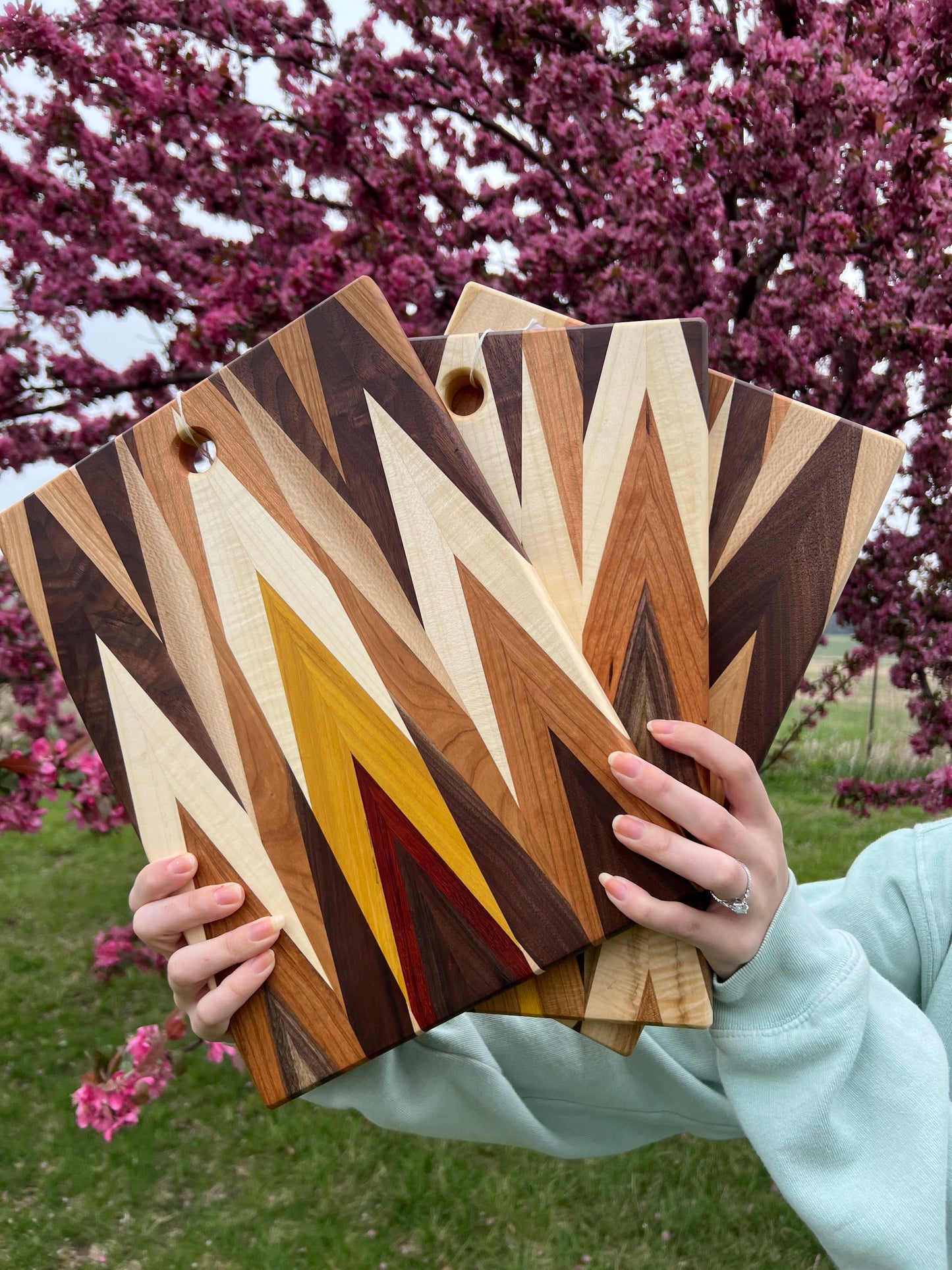 Handcrafted Amish Chevron cutting board with multi-wood inlay and beeswax finish, measuring 9.5 by 14 inches.
