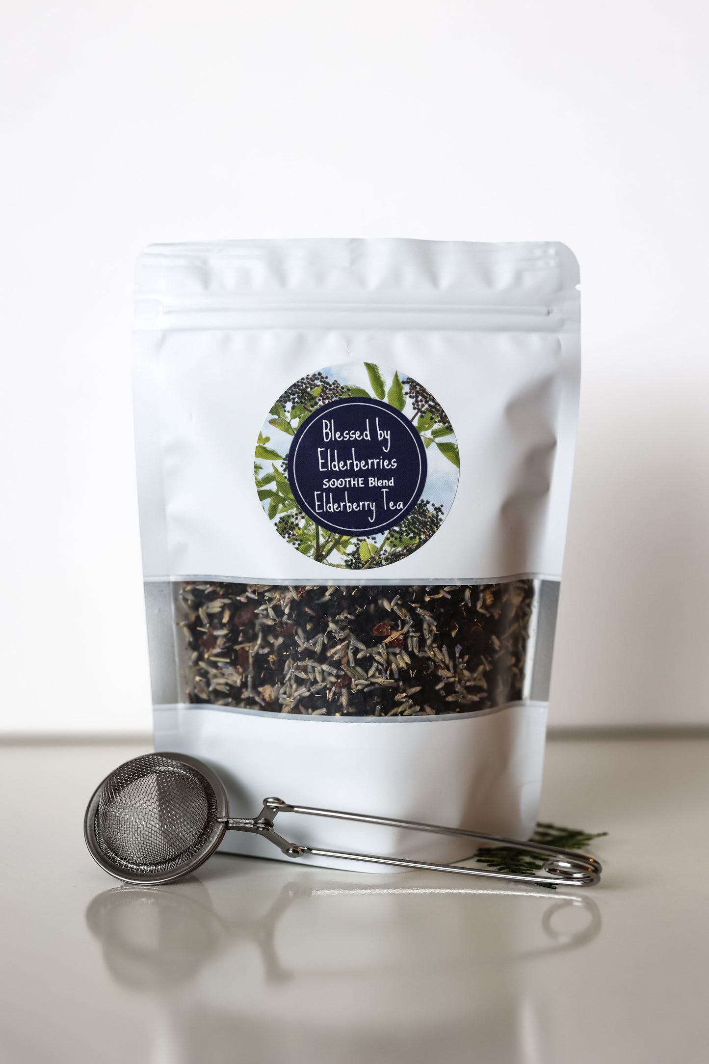 Blessed by Elderberries Soothe Blend Elderberry Tea in a clear tea bag with dried elderberries and herbs, ready to brew.