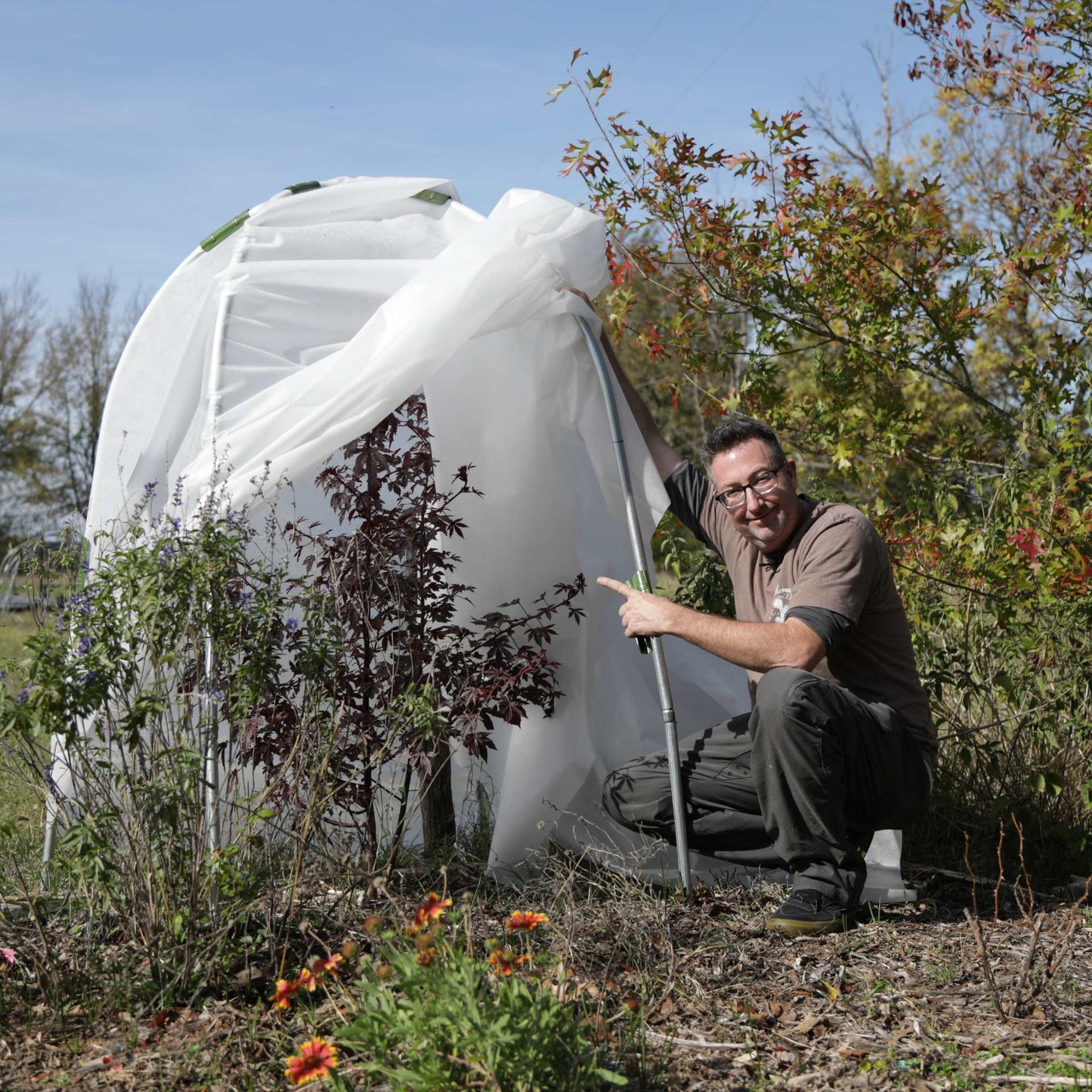 Bootstrap Farmer DIY Tree Protector Kit installed around young trees in a garden setting for protection and growth.