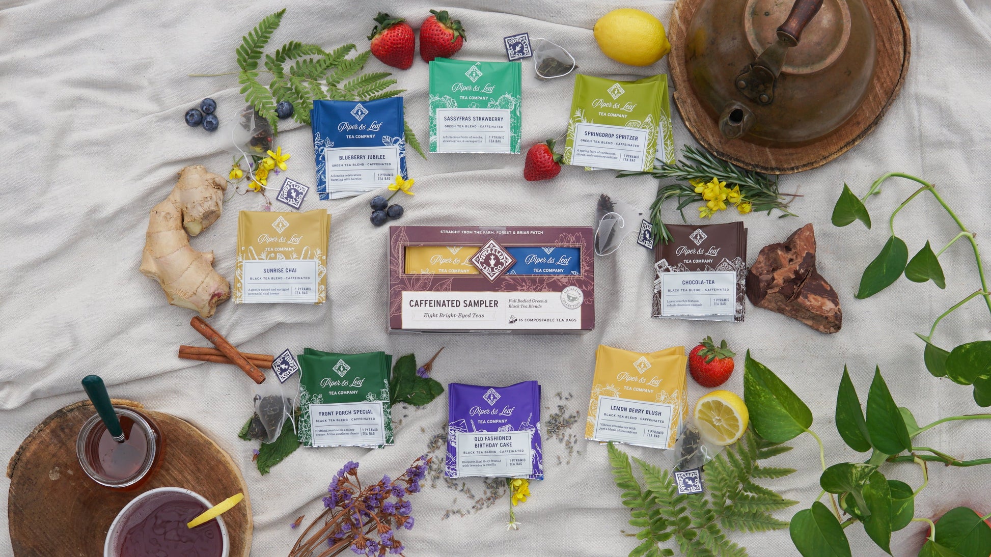 Assorted Piper and Leaf Tea Co. caffeinated tea bags in a tasting flight box, showcasing individual tea bag packaging and branding.