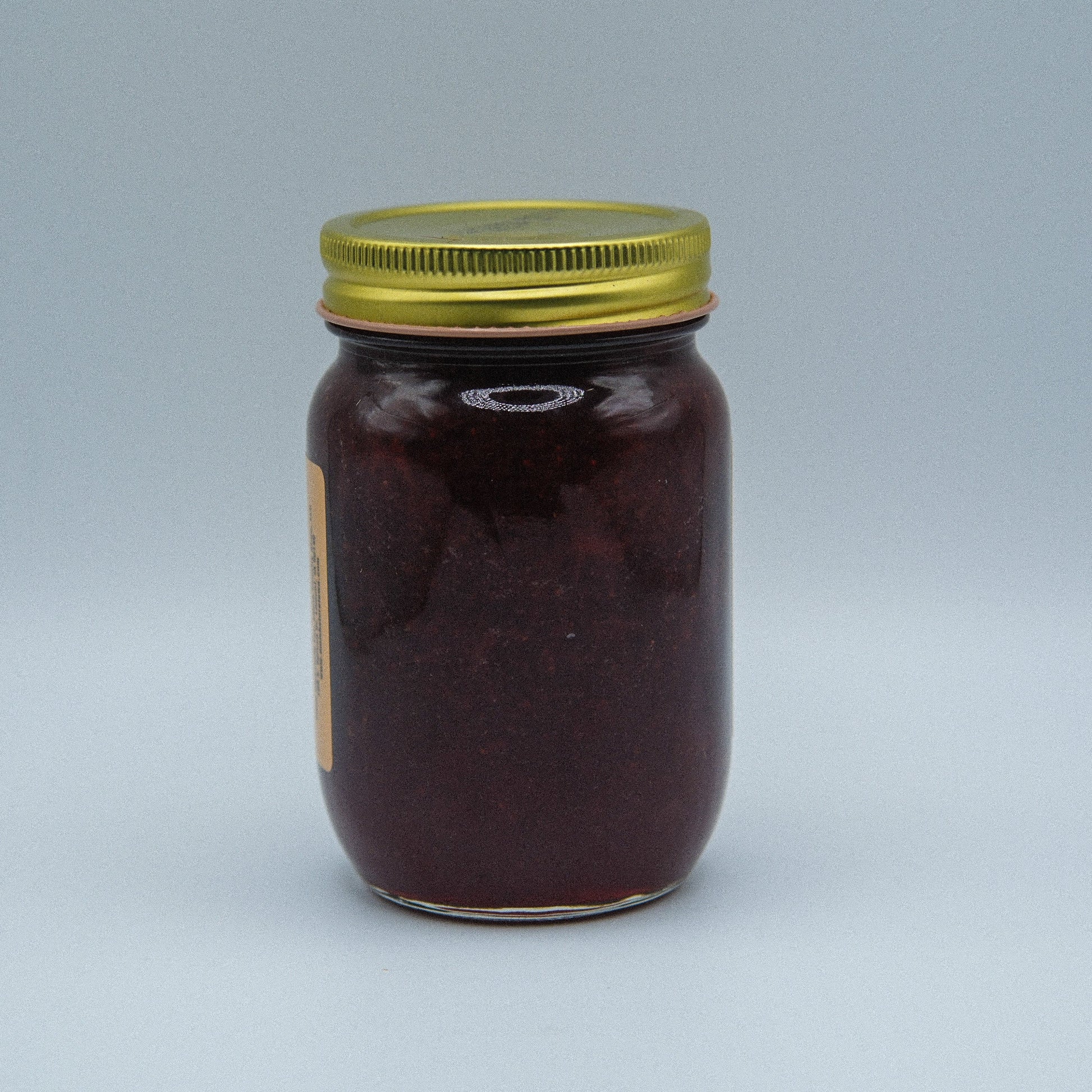 Canned Amish Country Store strawberry jam in an 18oz jar, with a bright red jam visible through the glass.