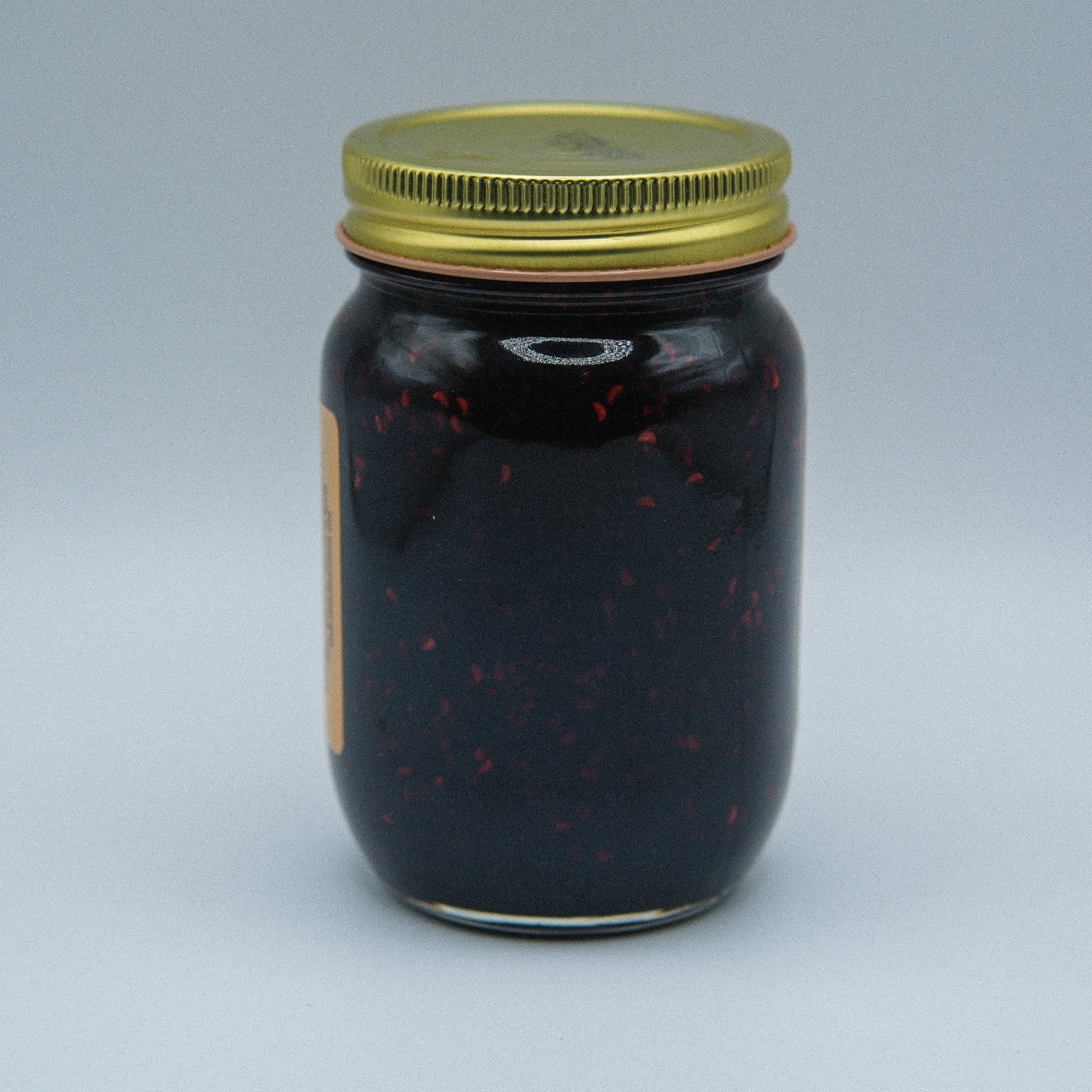 Canned Amish Country Store Triple Berry Jam jar with a clear label, showcasing the vibrant berry mixture inside.