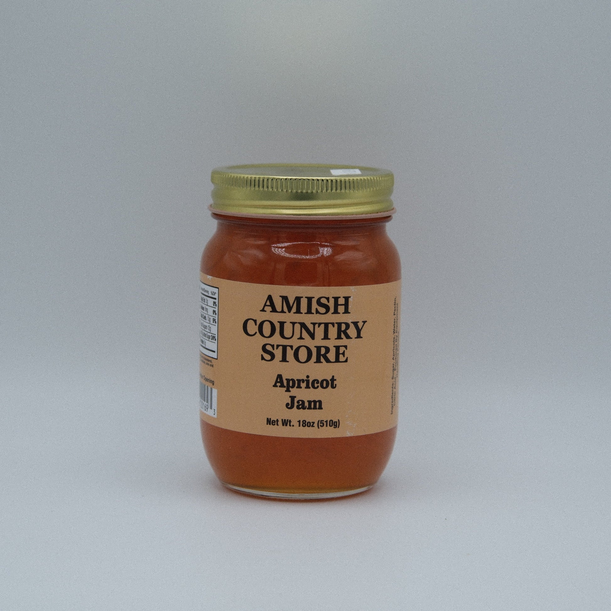 Canned apricot jam in a jar from Amish Country Store, showing fresh apricots and the jam's orange color.