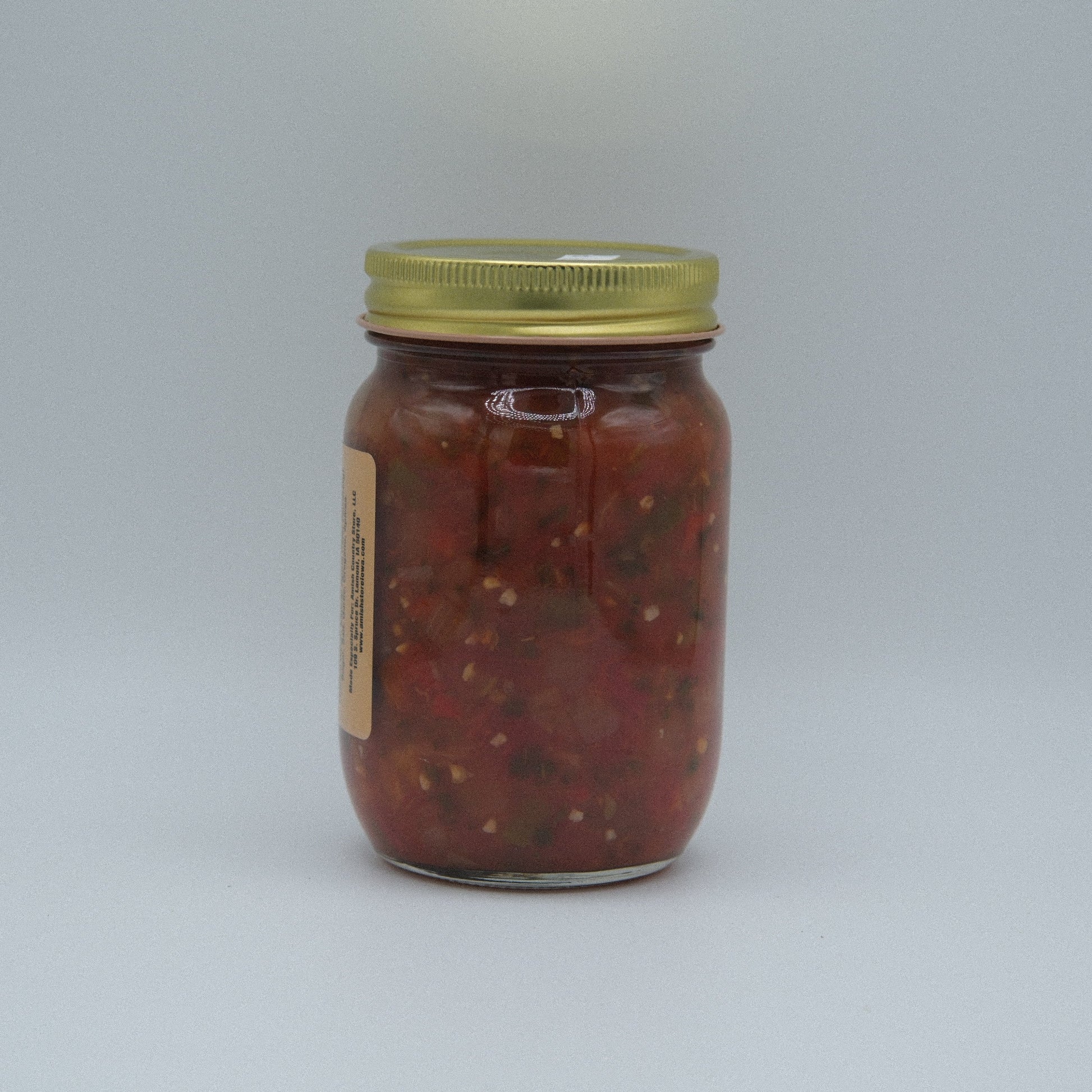 Canned Hot Salsa by Amish Country Store in 14.5 oz jar, vibrant red salsa with visible chili peppers and fresh ingredients.