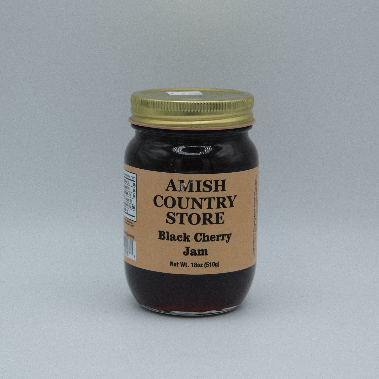 Canned black cherry jam in a jar from Amish Country Store, 18 oz, with a label showing fresh black cherries and jam texture.