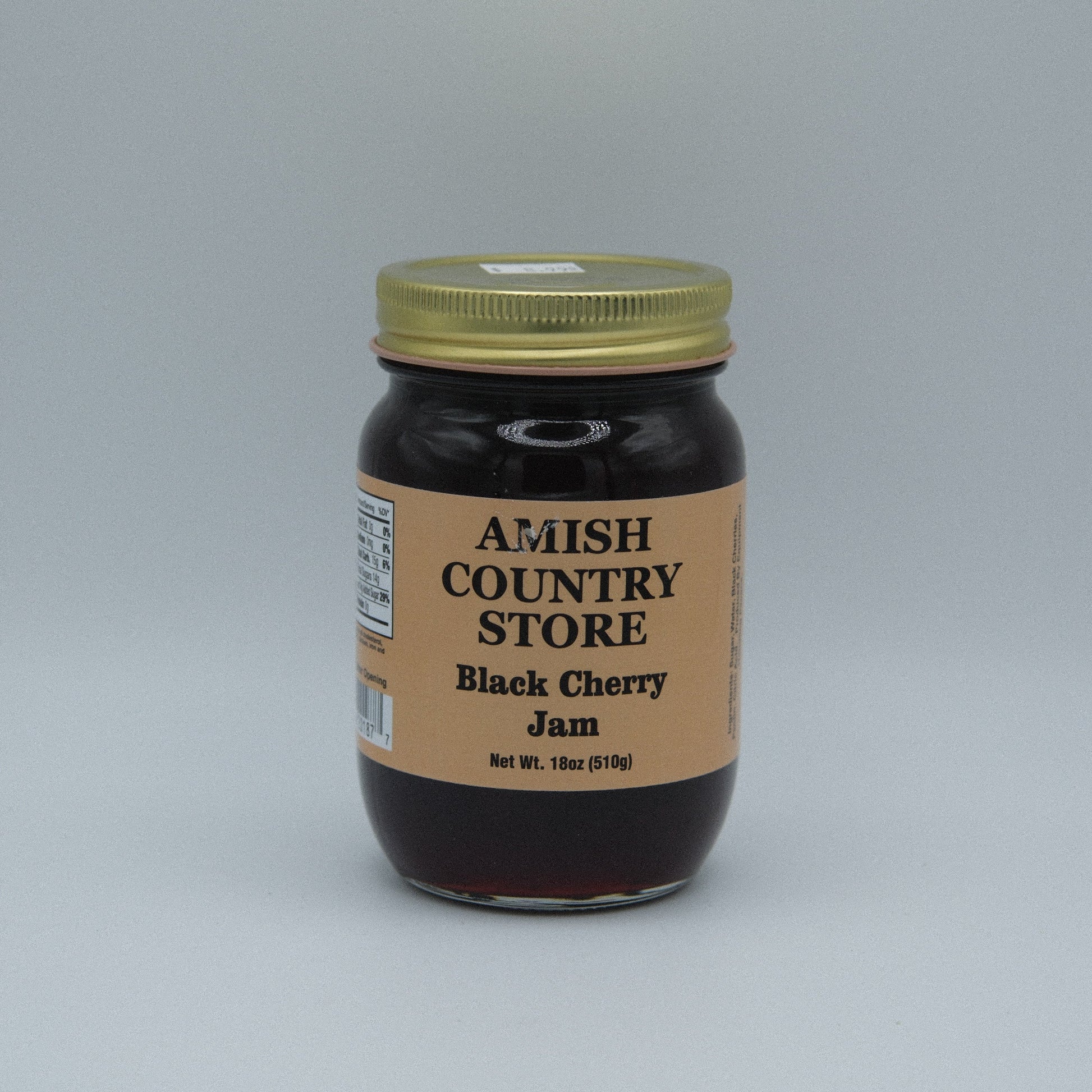 Canned black cherry jam in a jar from Amish Country Store, 18 oz, with a label showing fresh black cherries and jam texture.