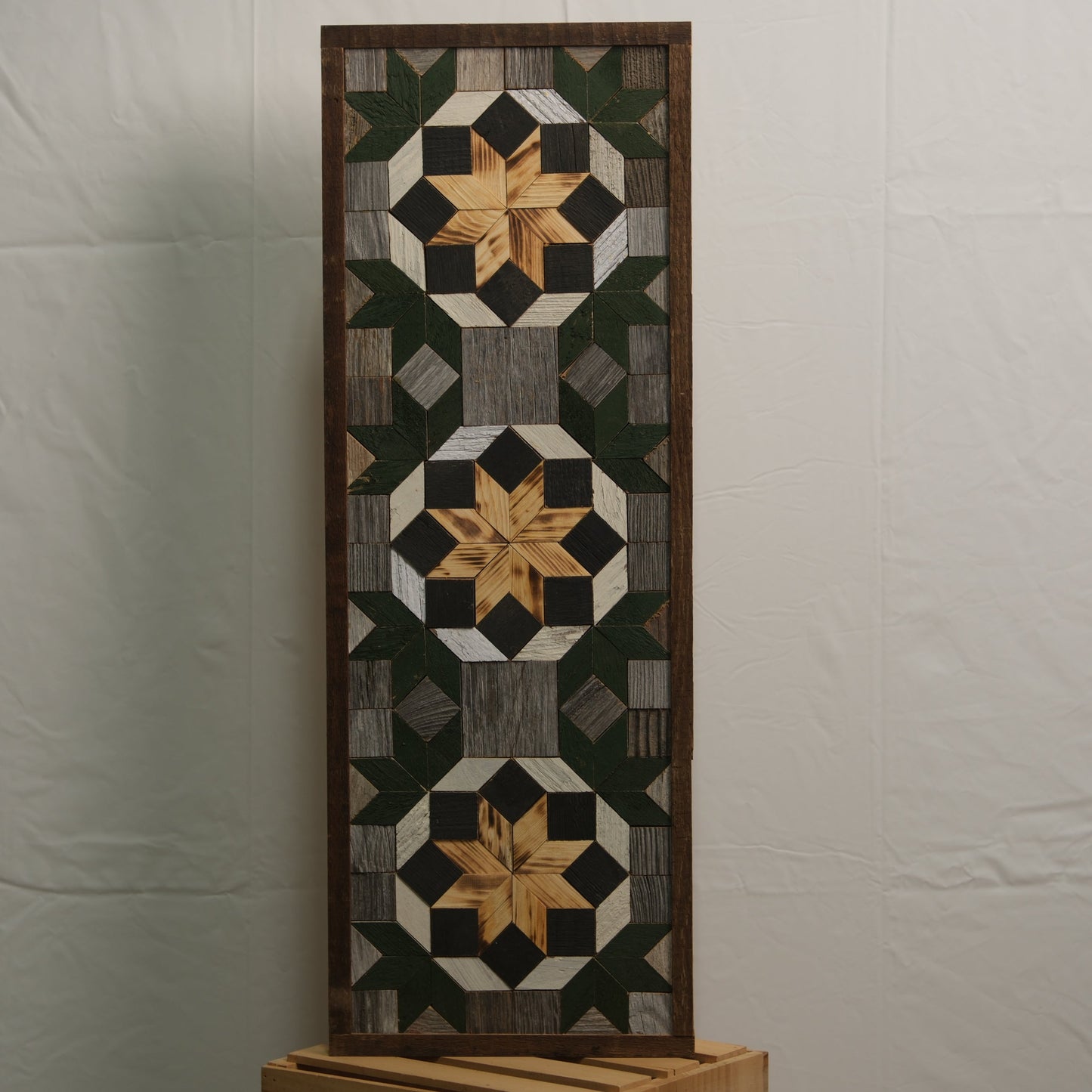Amish handmade barn quilt banner in vibrant geometric patterns, measuring 10.5 x 30 inches, displayed outdoors.