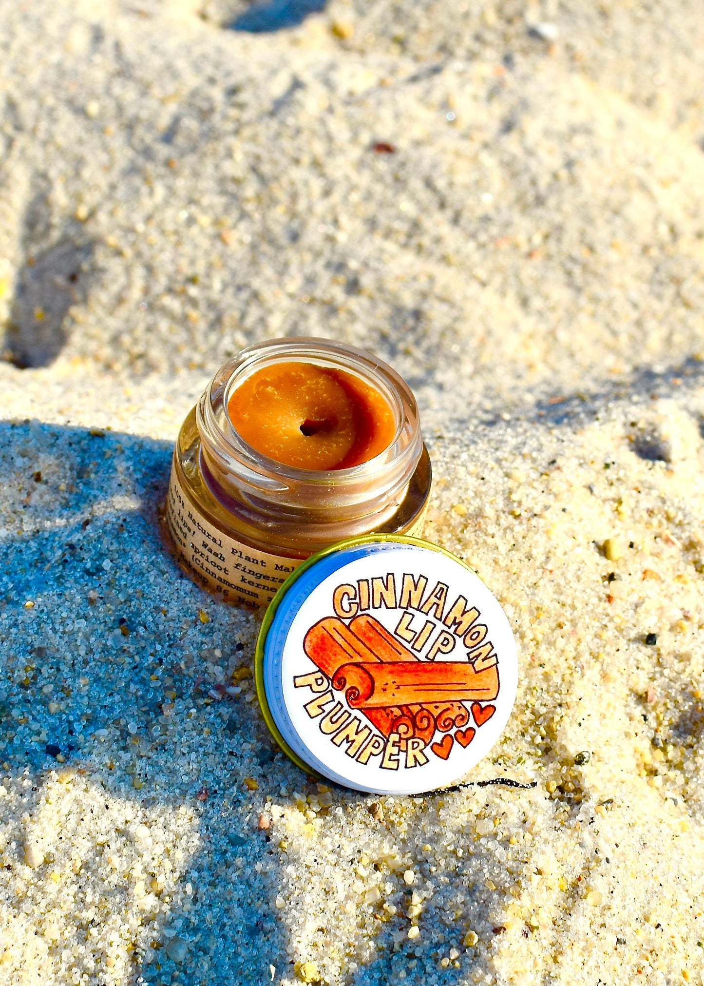 Plant Makeup Cinnamon Lip Plumper in natural light, showing glossy, plump lips with a hint of cinnamon color.