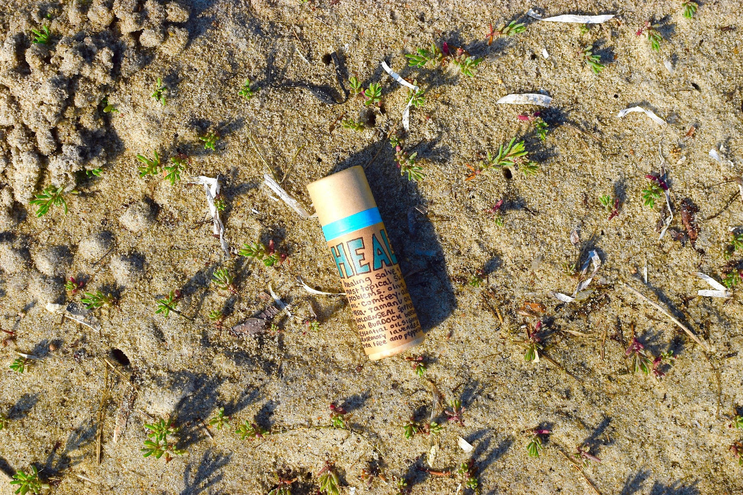 Plant Makeup Heal All Balm jar with natural ingredients and herbal infusion, shown in a close-up shot.