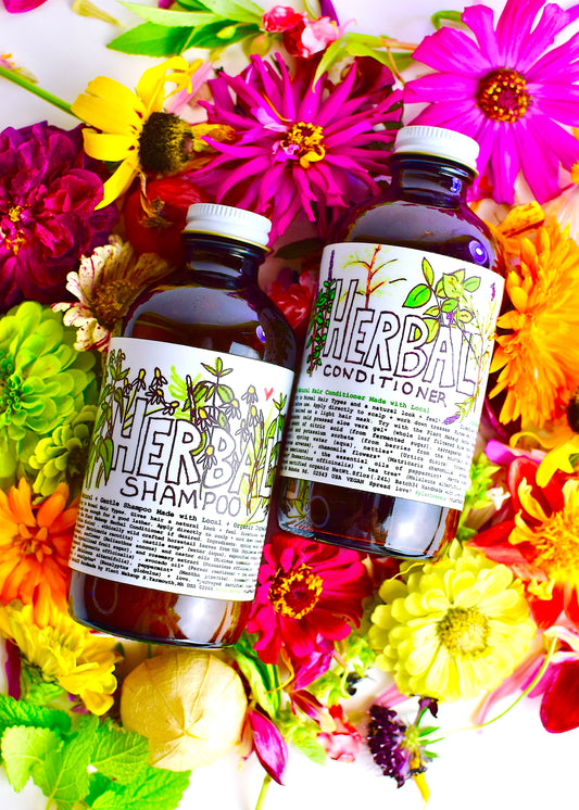 Herbal conditioner and shampoo bottles with botanical labels surrounded by colorful flowers, natural hair care products, plant-based hair treatment