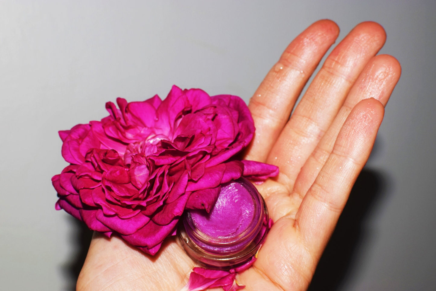 Dragon Fruit Lip Gloss by Plant Makeup displayed in a clear container with vibrant pink color and glossy finish.