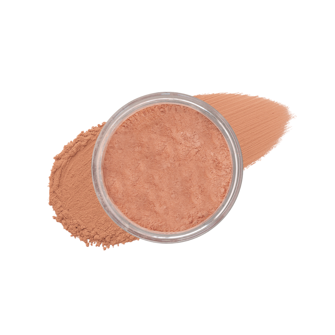 Dark loose mineral foundation from Taylor Made Organics in a jar with a smudged powder appearance.