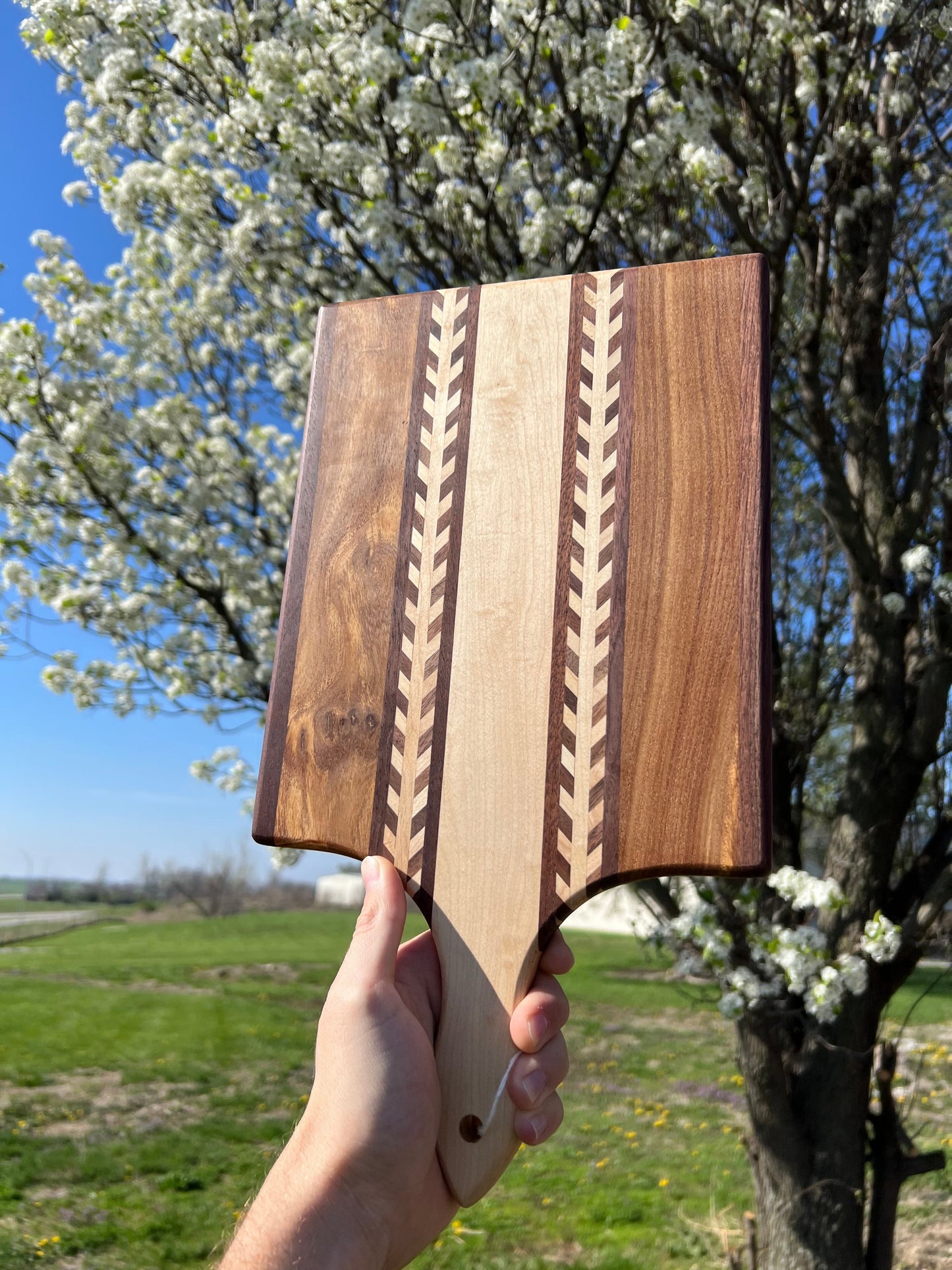 Amish Handmade Wheat Inlay Cutting Board with mixed hardwood paddle, kitchen accessory for food prep and serving.