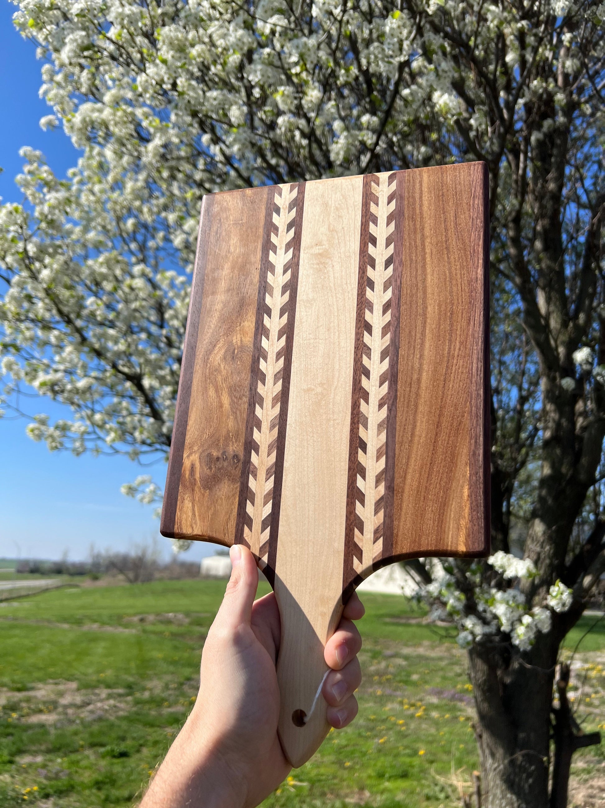 Amish Handmade Wheat Inlay Cutting Board with mixed hardwood paddle, kitchen accessory for food prep and serving.