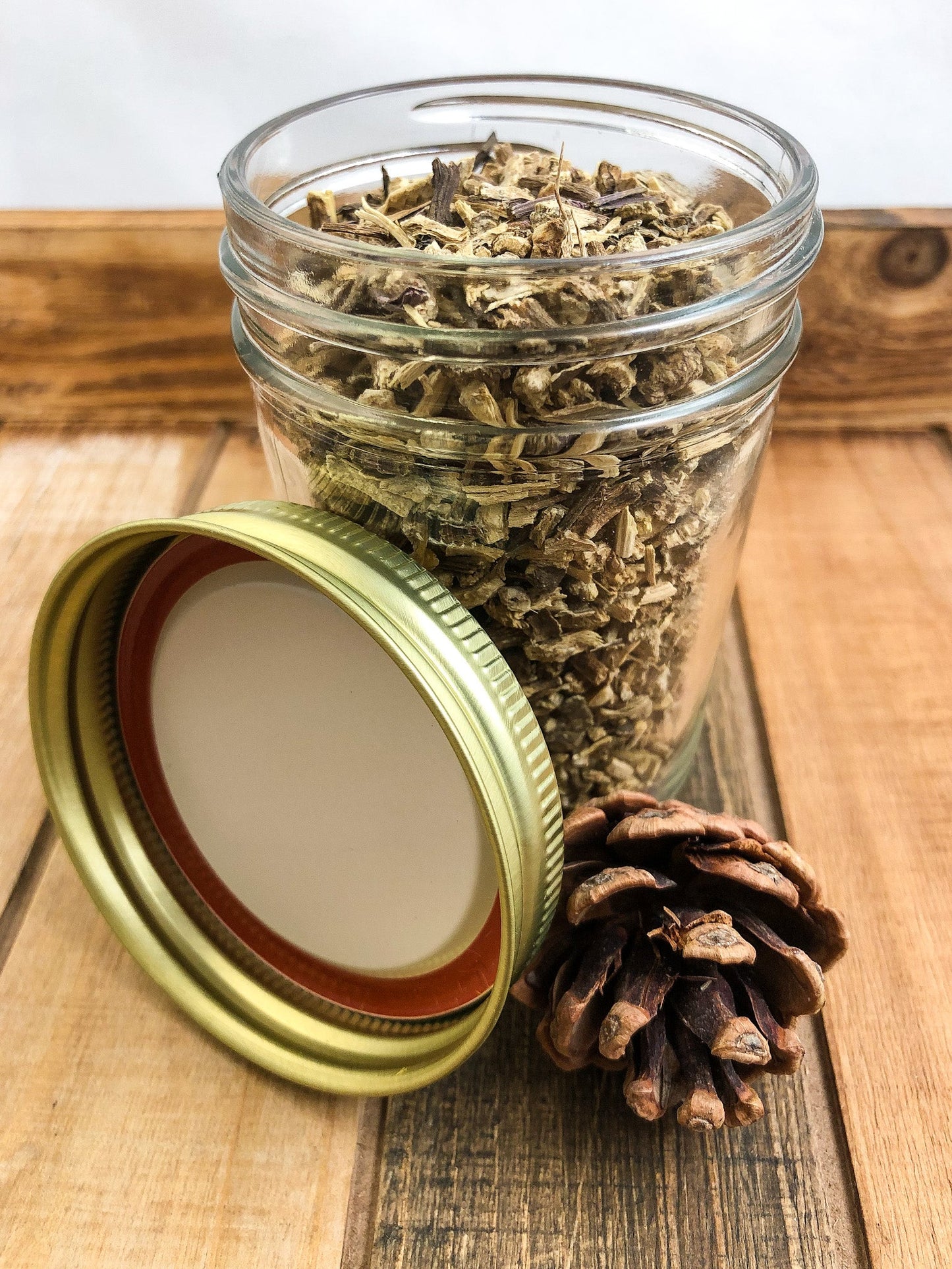 Small jar of dried Echinacea root herbs in a white wooden herbalroseapothecary jar for herbal remedies.