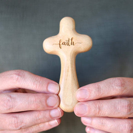 Wooden engraved prayer crosses from Dennehey Design Co. featuring detailed carvings, displayed on a neutral background.