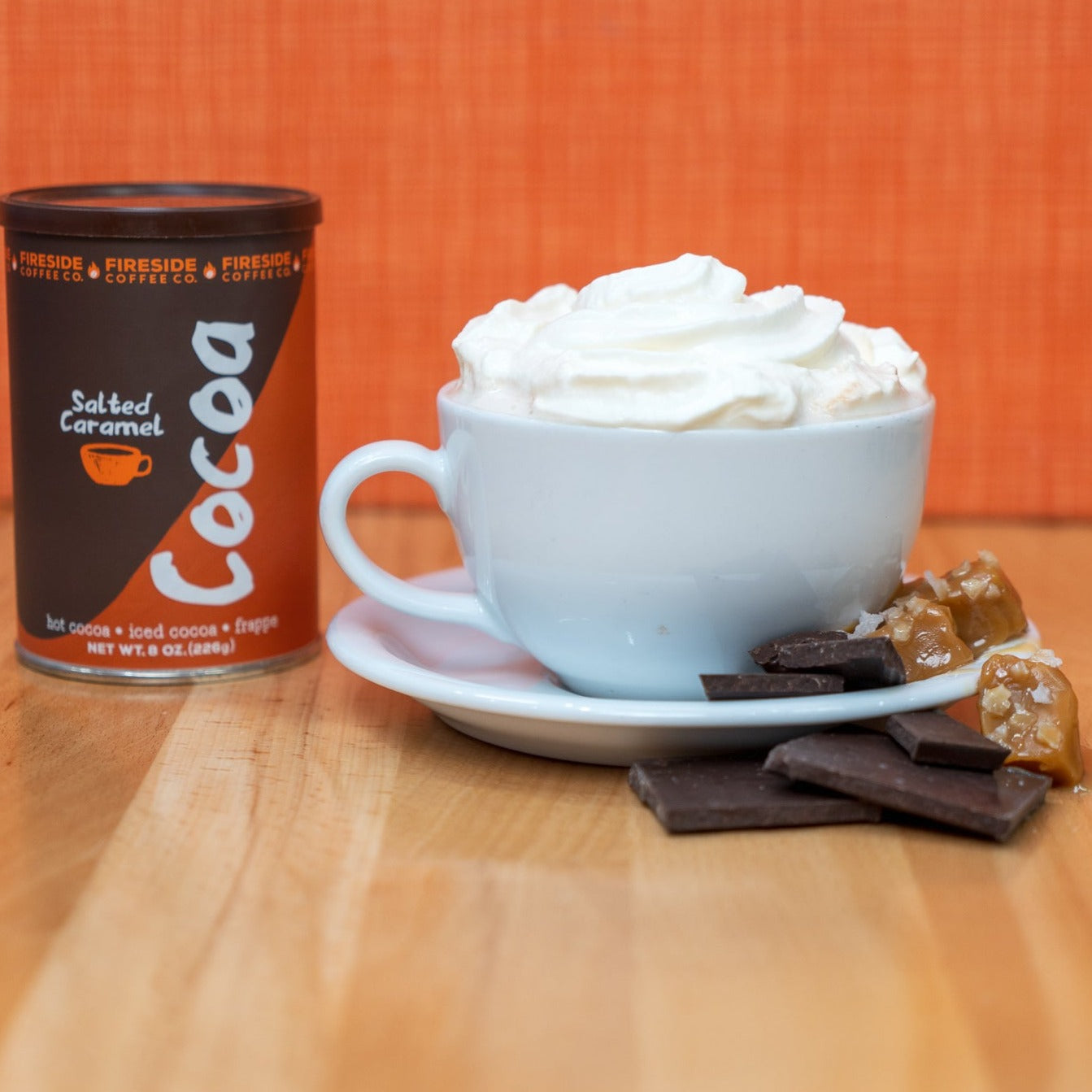 A steaming cup of Fireside Coffee Co. salted caramel cocoa topped with whipped cream and caramel drizzle.