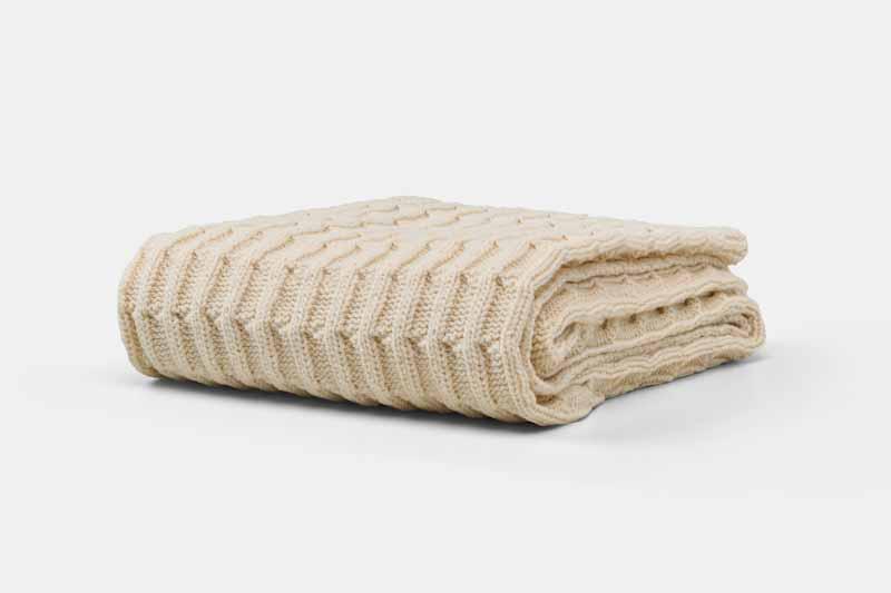 Folded American Blossom Linens cotton knitted baby blanket showing soft, cozy texture and lightweight design.