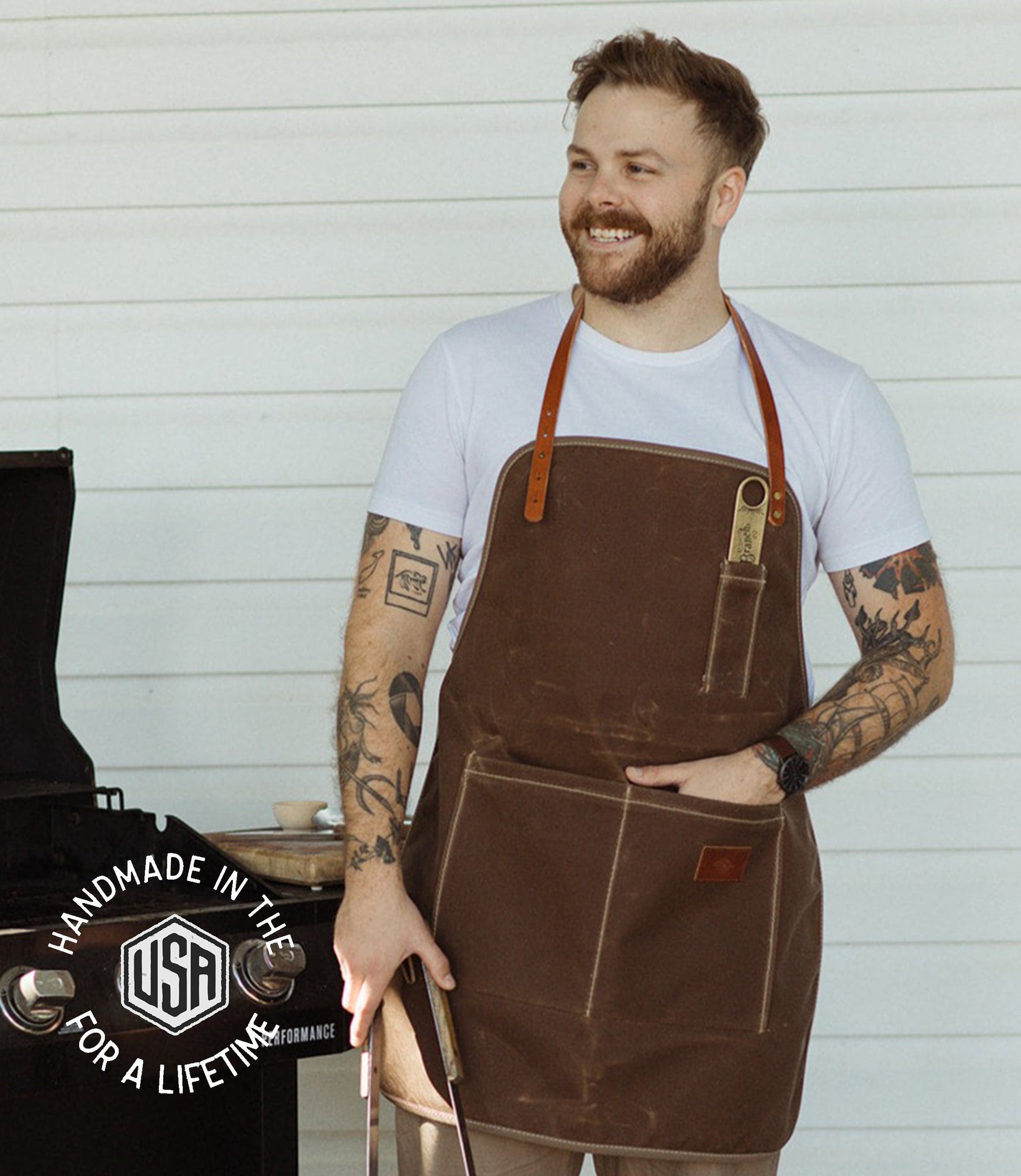 Full-length waxed canvas apron by The Local Branch with logo, showcasing durable, USA-made craftsmanship for work or cooking.