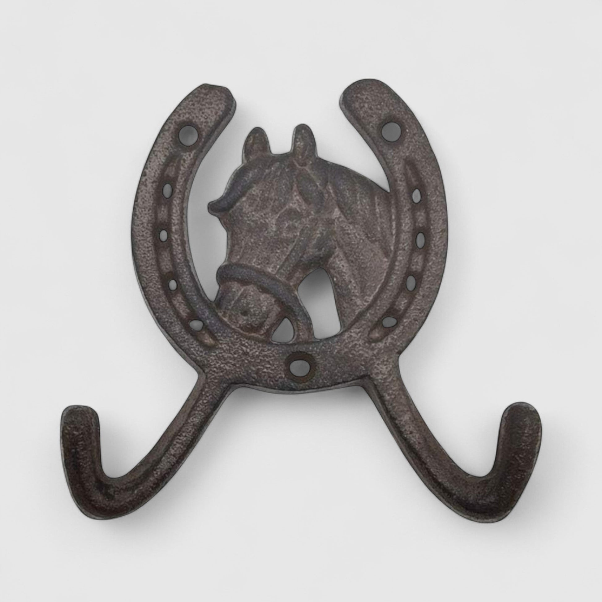 Rustic cast iron horseshoe wall hook with horse head design from Iron & Blossom, ideal for home decor and coat or key hanging.