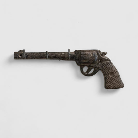 Vintage Iron & Blossom Western cast iron gun hooks with revolver design for wall organization and decorative storage.