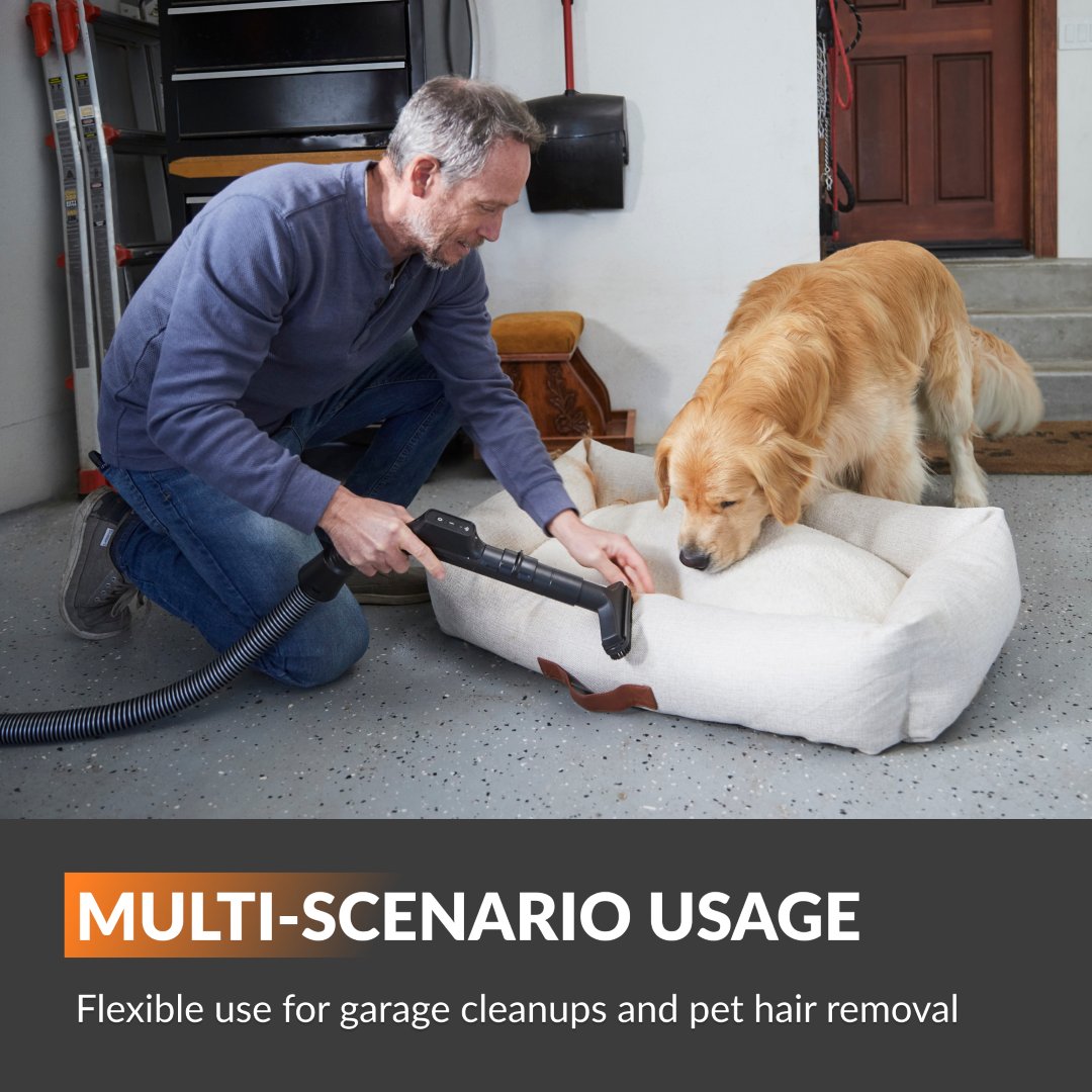 Giraffe Tools US Grandstorm retractable garage vacuum with hose and attachments, mounted on a garage wall for convenient cleaning.