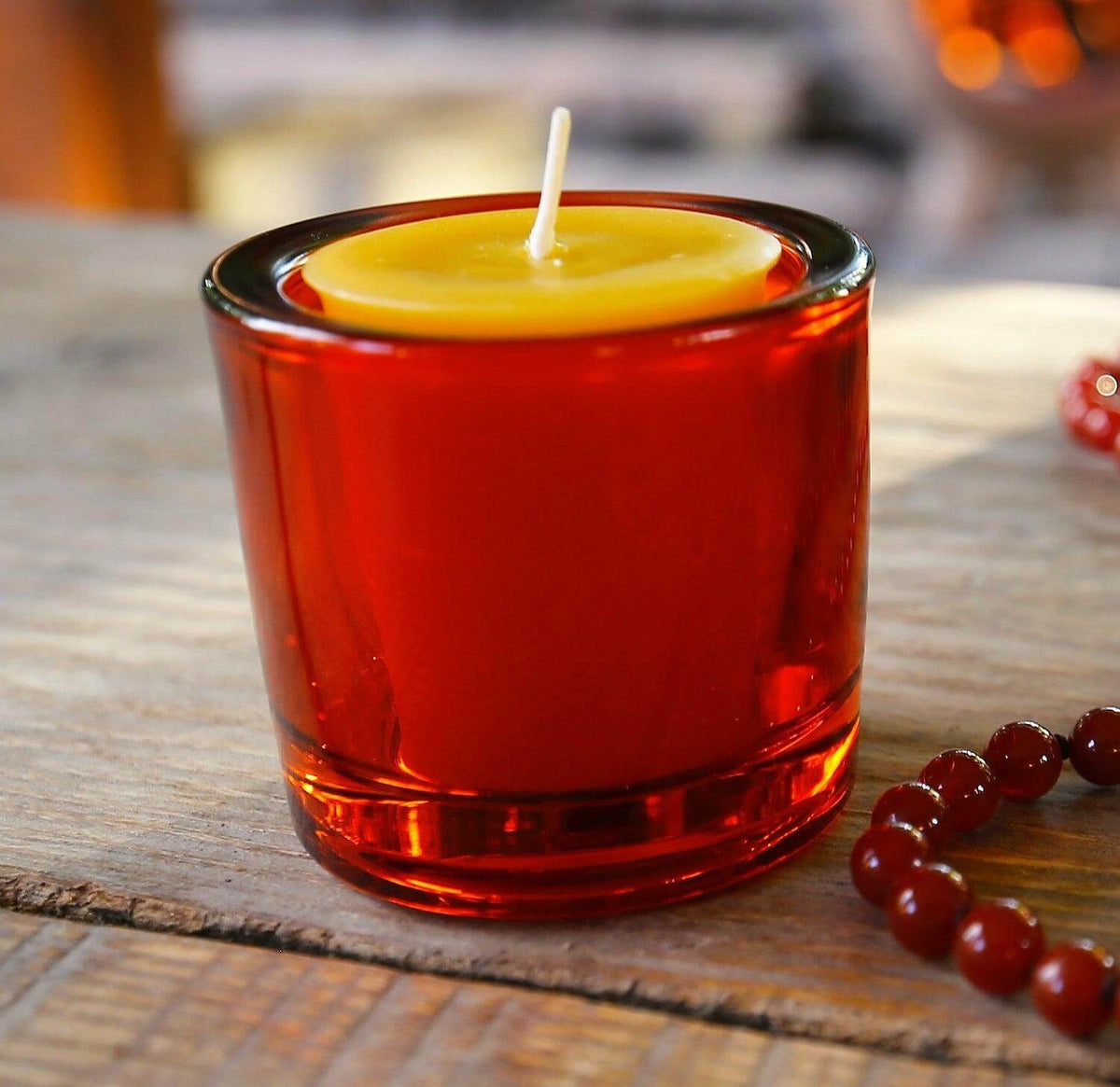Bluecorn Candles heavy glass votive candle holder made from recycled glass, showcasing a clear, sturdy design with a candle inside.