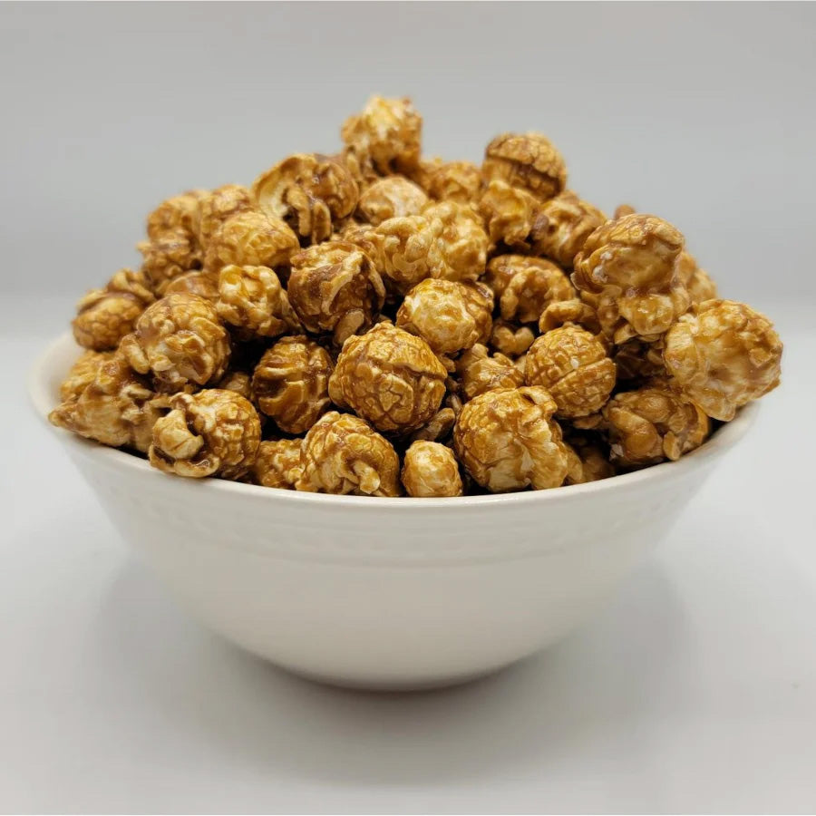 8 oz HR Poppin' Snacks caramel popcorn in a clear bag with golden caramel coating and crunchy popcorn pieces.