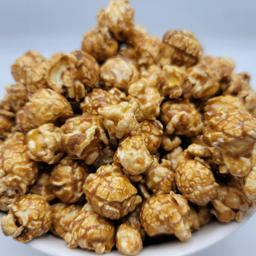 8 oz bag of HR Poppin' Snacks caramel popcorn, golden-brown, coated with rich caramel, in a clear snack bag.