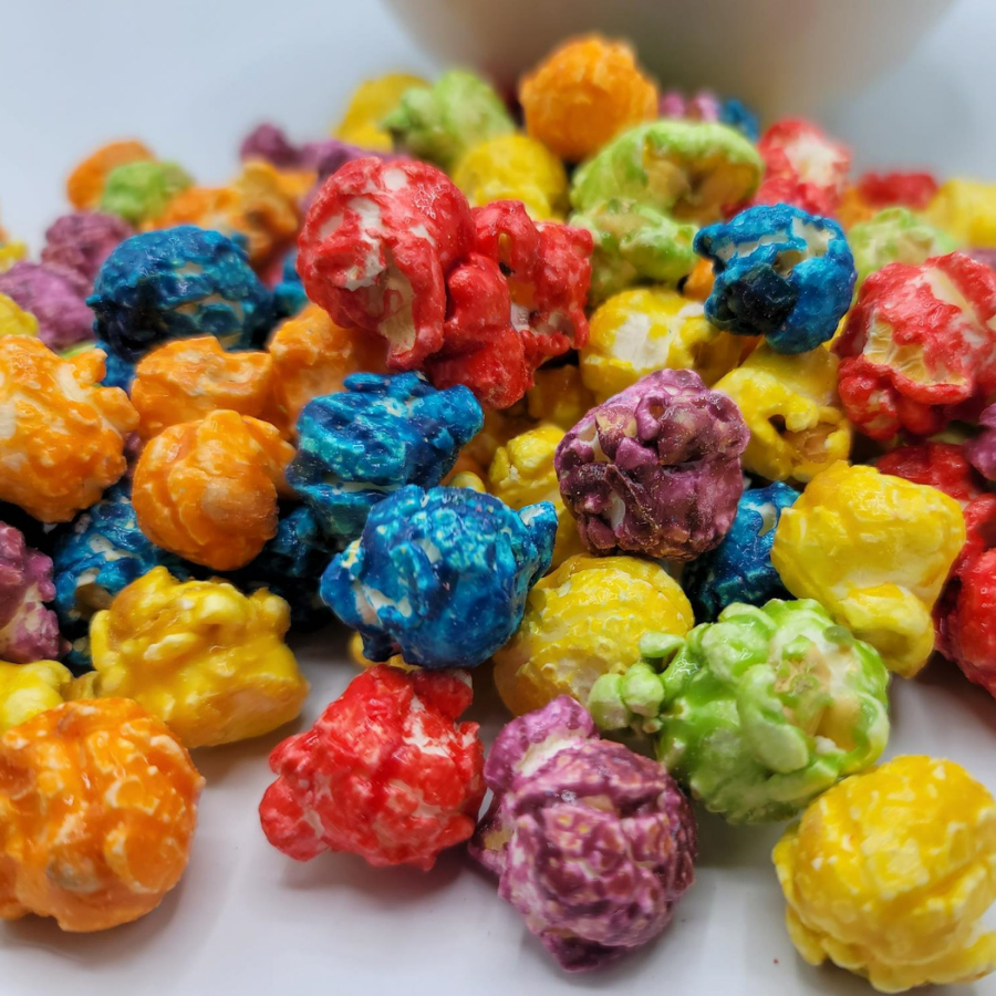 Colorful rainbow popcorn in a bowl, showcasing bright, coated snacks from HR Poppin' Snacks, ideal for snacking or parties.