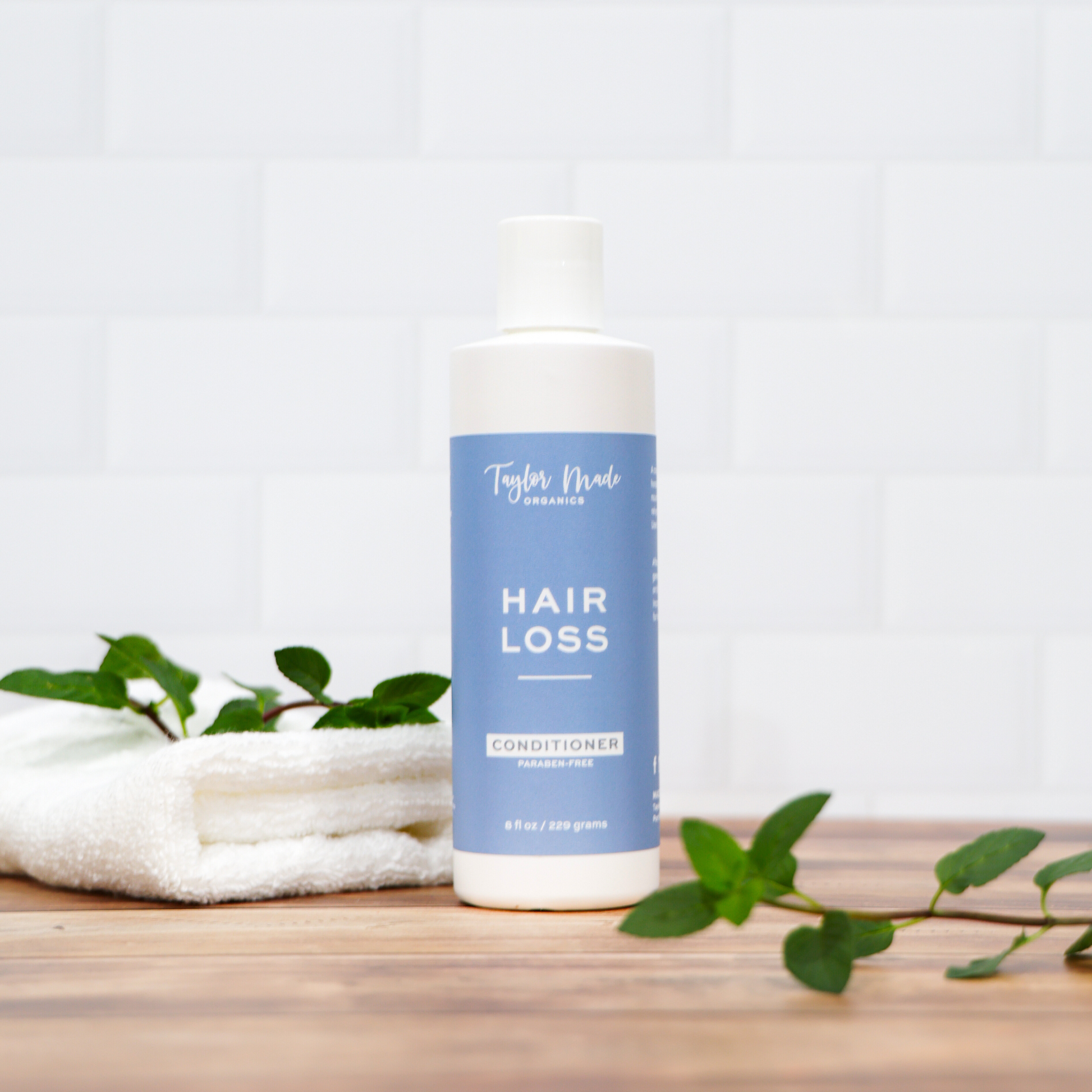 Organic hair loss conditioner with silk protein by Taylor Made Organics, featuring a bottle of nourishing hair care treatment.